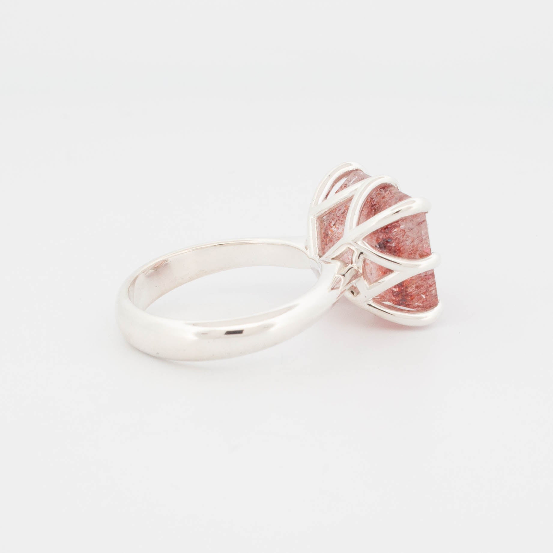 "Sterling silver ring featuring a large rectangular cabochon with a red and copper-toned splatter effect, secured by bold claw prongs; contemporary statement design known as the Splatter Ring."