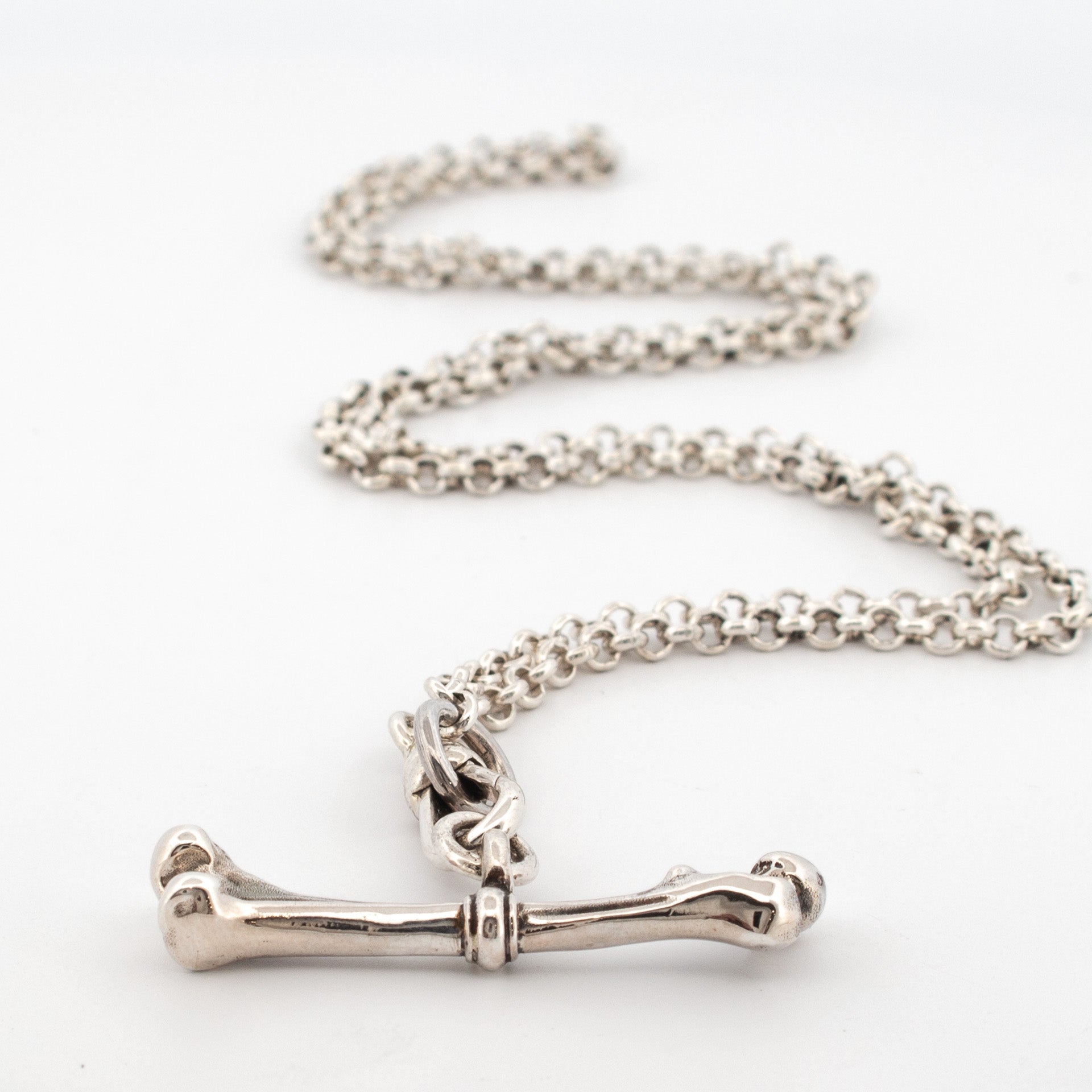 This solid sterling silver necklace features a sculpted bone toggle fob clasp on a heavy belcher chain.