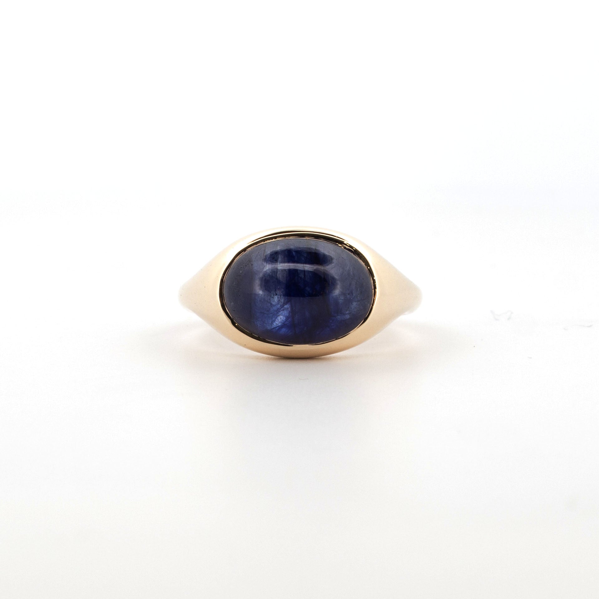 9ct yellow gold ring with oval cabochon sapphire showing natural silk inclusions.