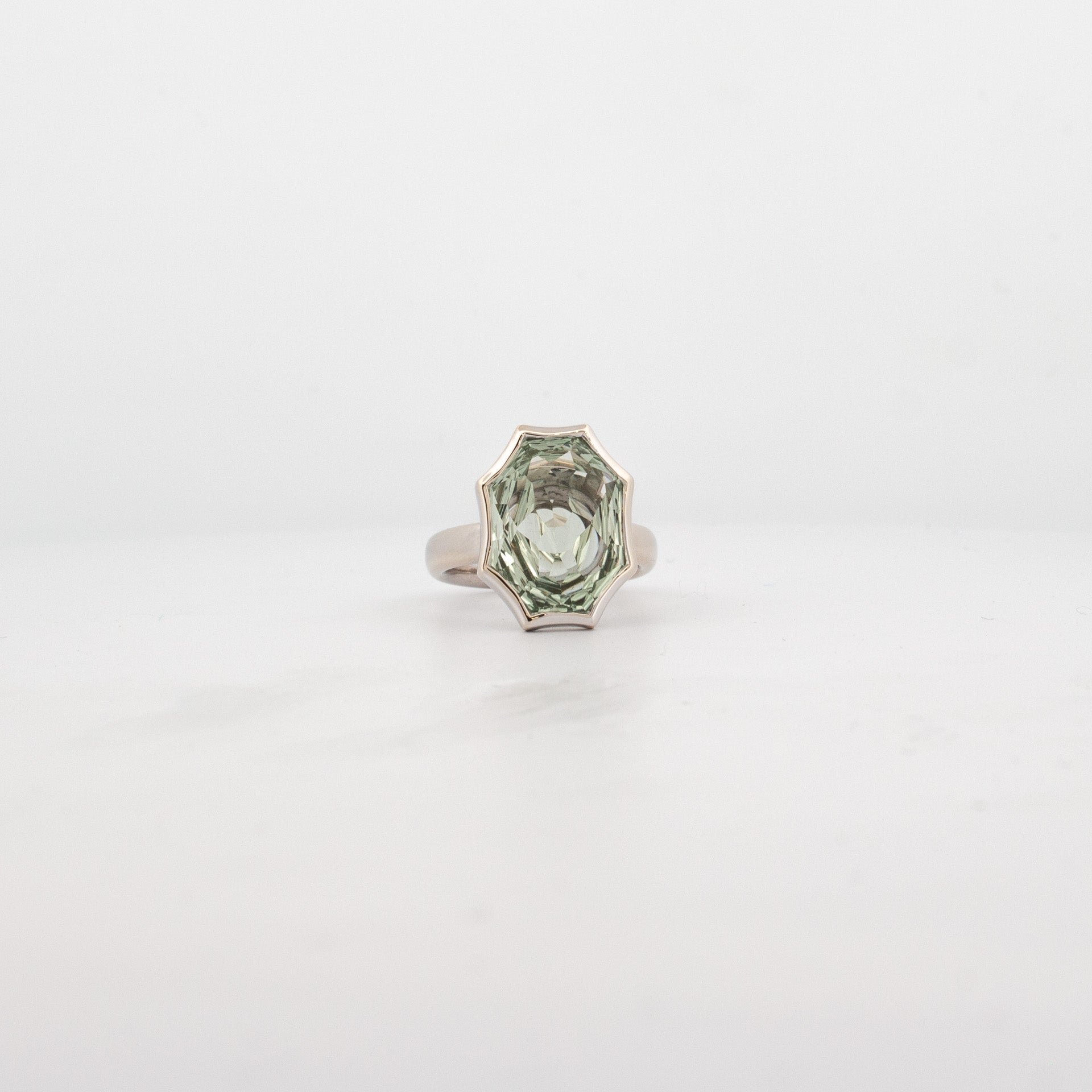 White gold ring with bezel-set fancy-cut green amethyst in star-edged custom shape.