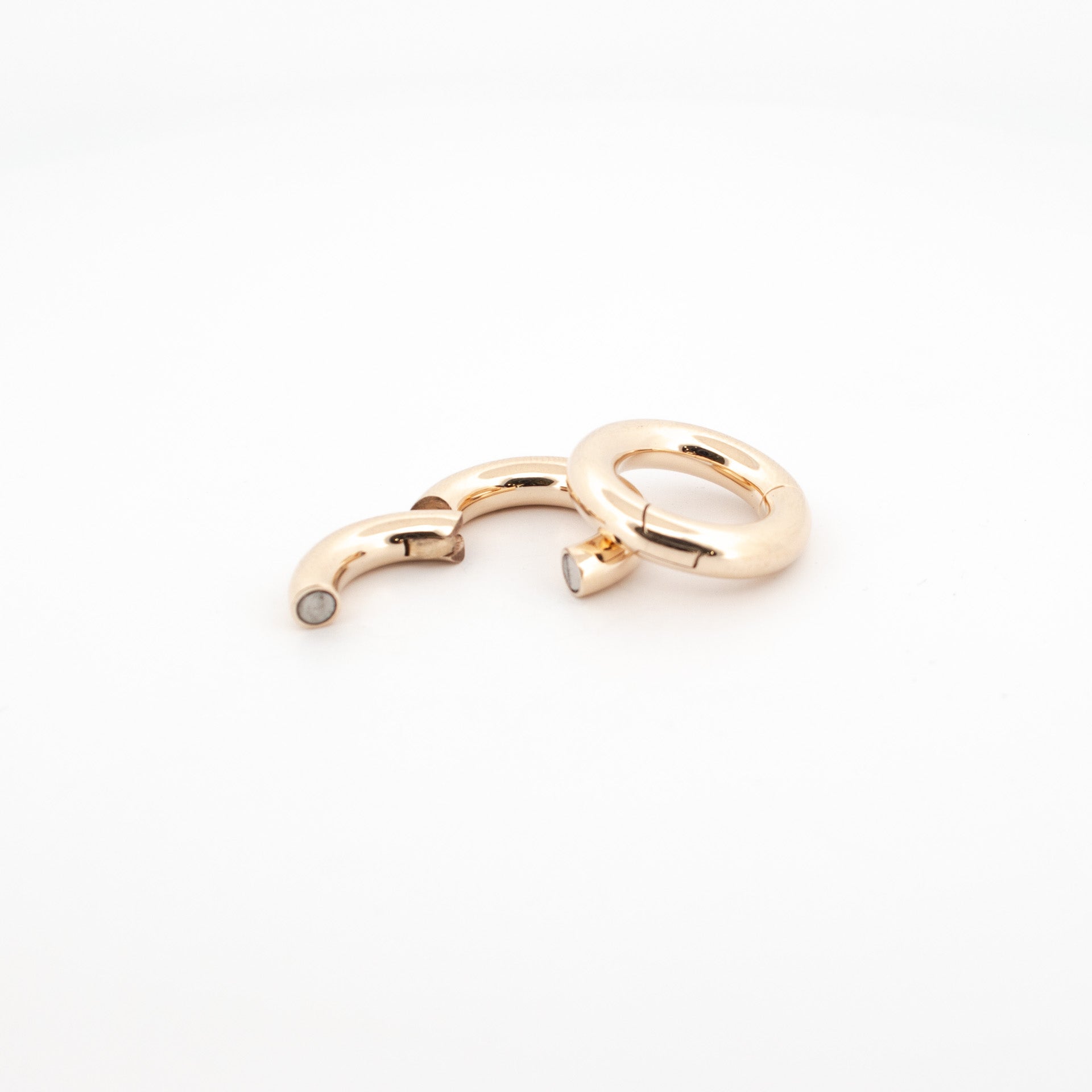A set of custom made 9ct gold earrings and a septum ring, with a golden finish and rare earth magnets.