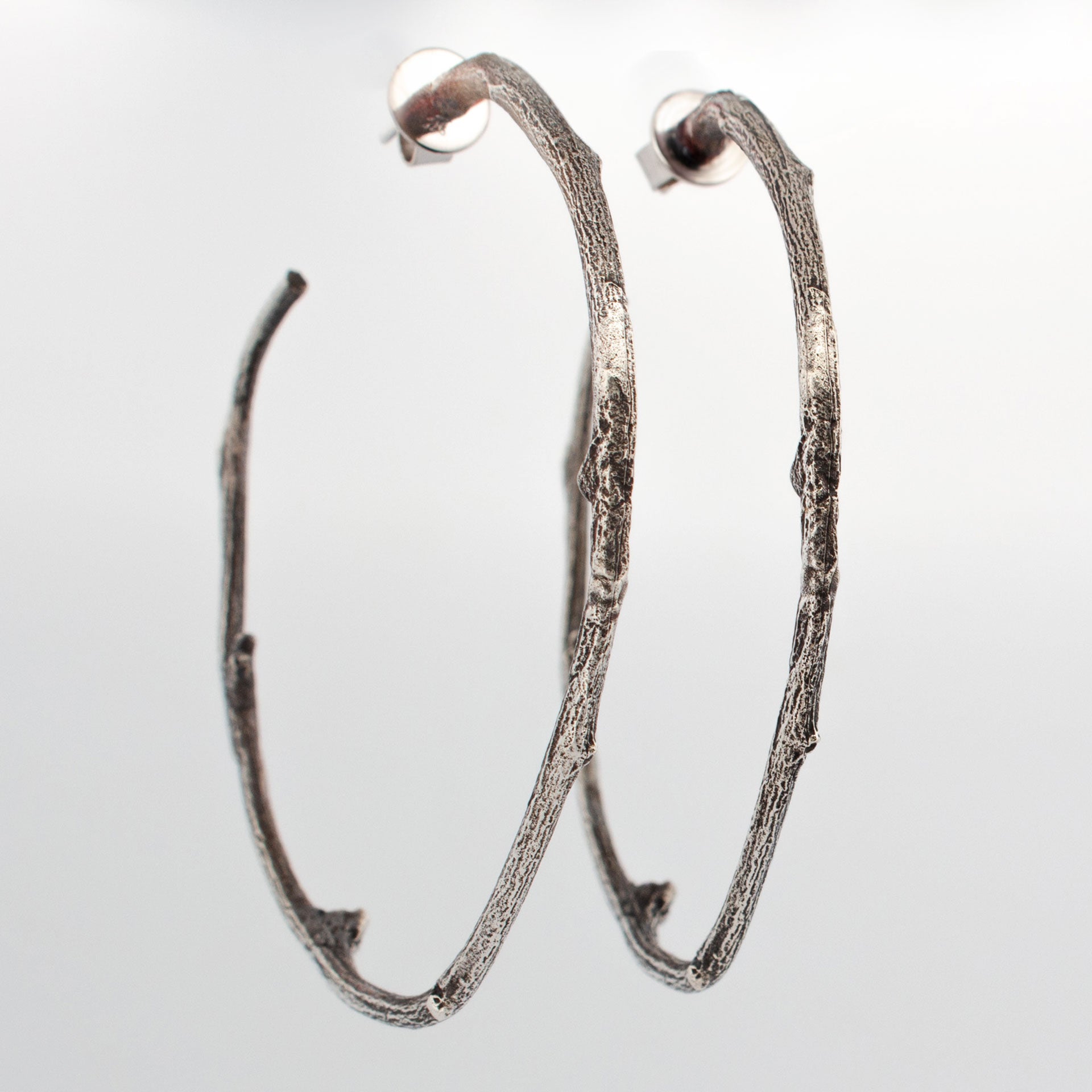 Sterling silver twig hoop earrings with natural bark texture