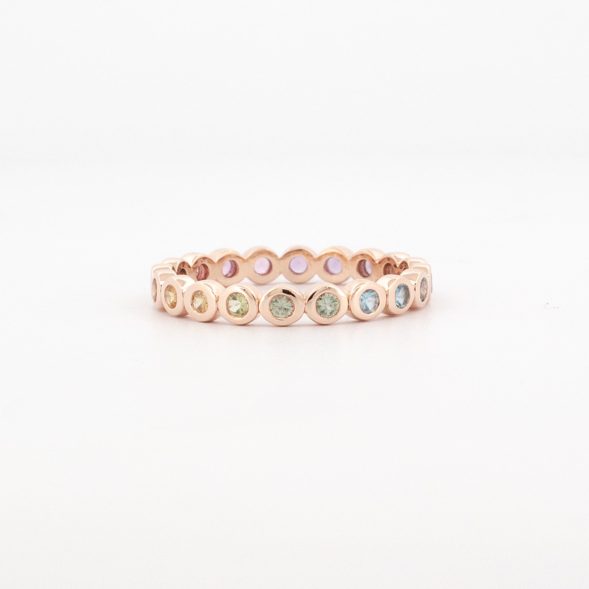 9ct rose gold full eternity ring bezel set with pastel colourfade sapphires in round settings and open gallery detailing.