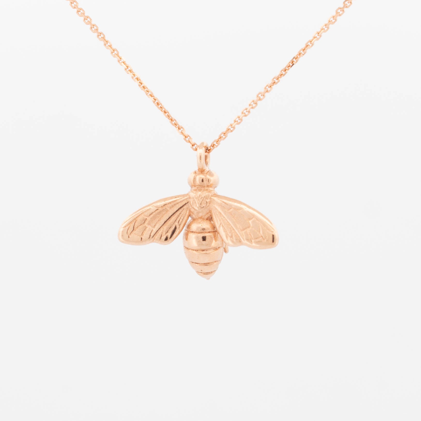 9ct rose gold bee pendant necklace with fine trace chain and detailed engraved wings and body.