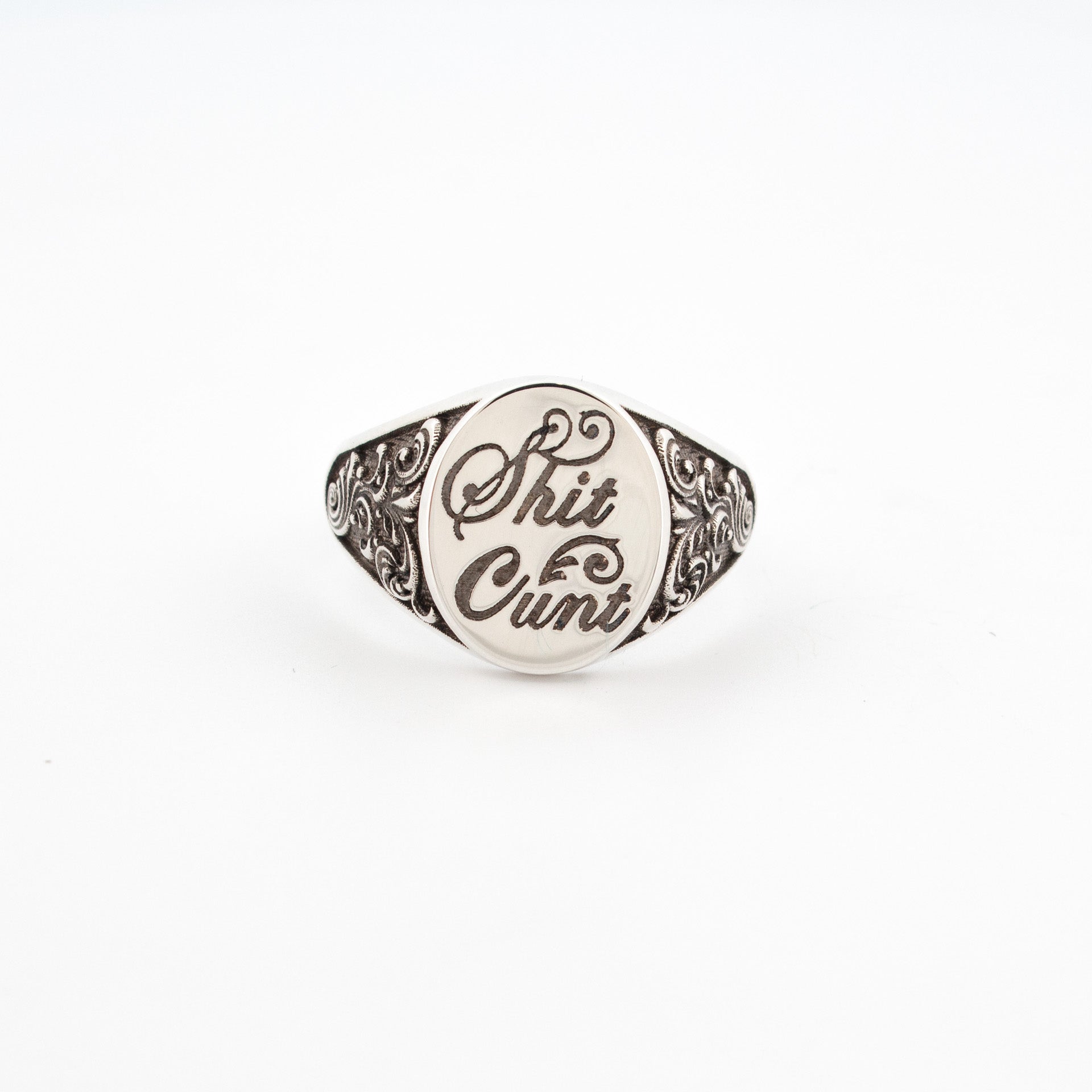 Sterling silver signet ring with engraved script lettering and ornate oxidised scrollwork shoulders.