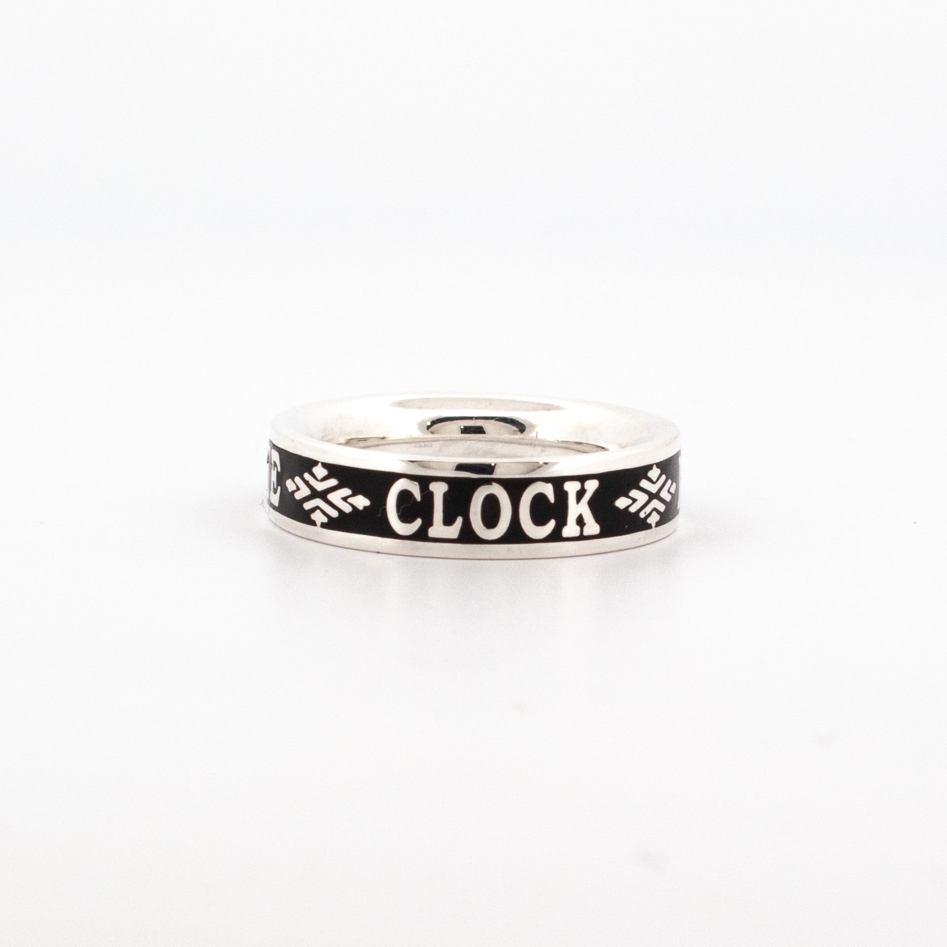 Sterling silver ring with oxidised black enamel band, featuring engraved text “The Clock is Ticking” and decorative motifs.