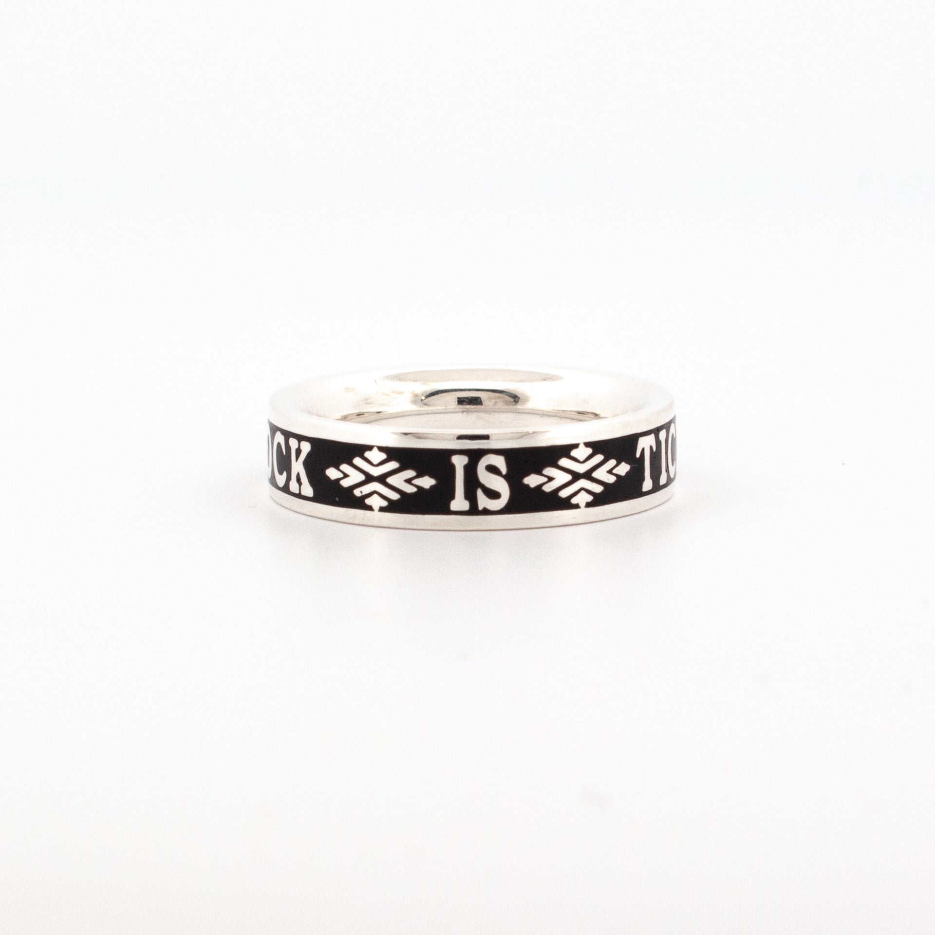 Sterling silver ring with oxidised black enamel band, featuring engraved text “The Clock is Ticking” and decorative motifs.