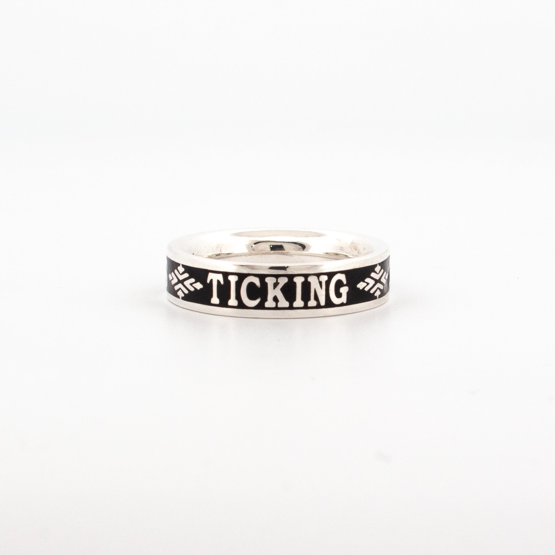 Sterling silver ring with oxidised black enamel band, featuring engraved text “The Clock is Ticking” and decorative motifs.