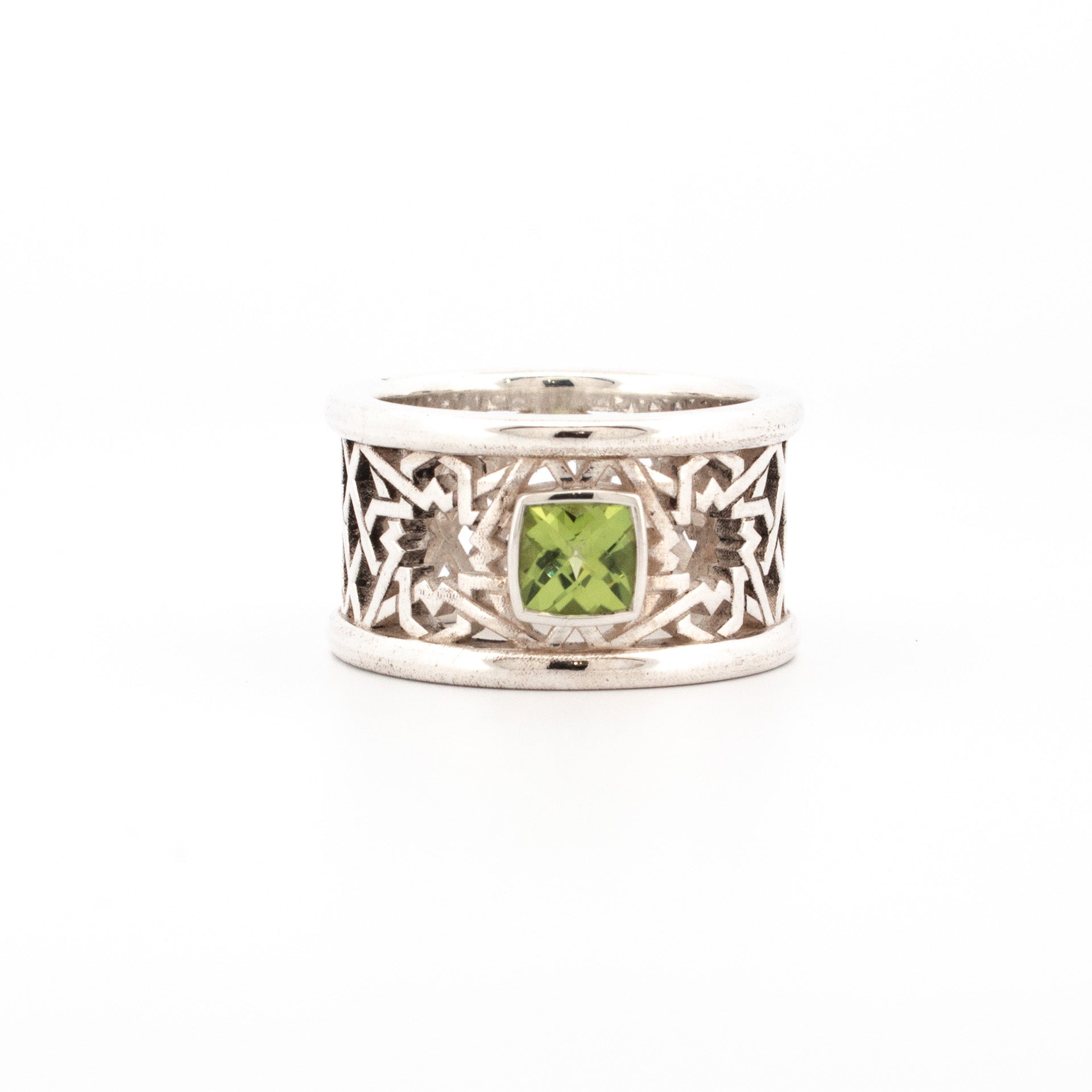 Sterling silver 14mm wide Alhambra-style ring with cushion-cut peridot in bezel setting, geometric lattice detail.