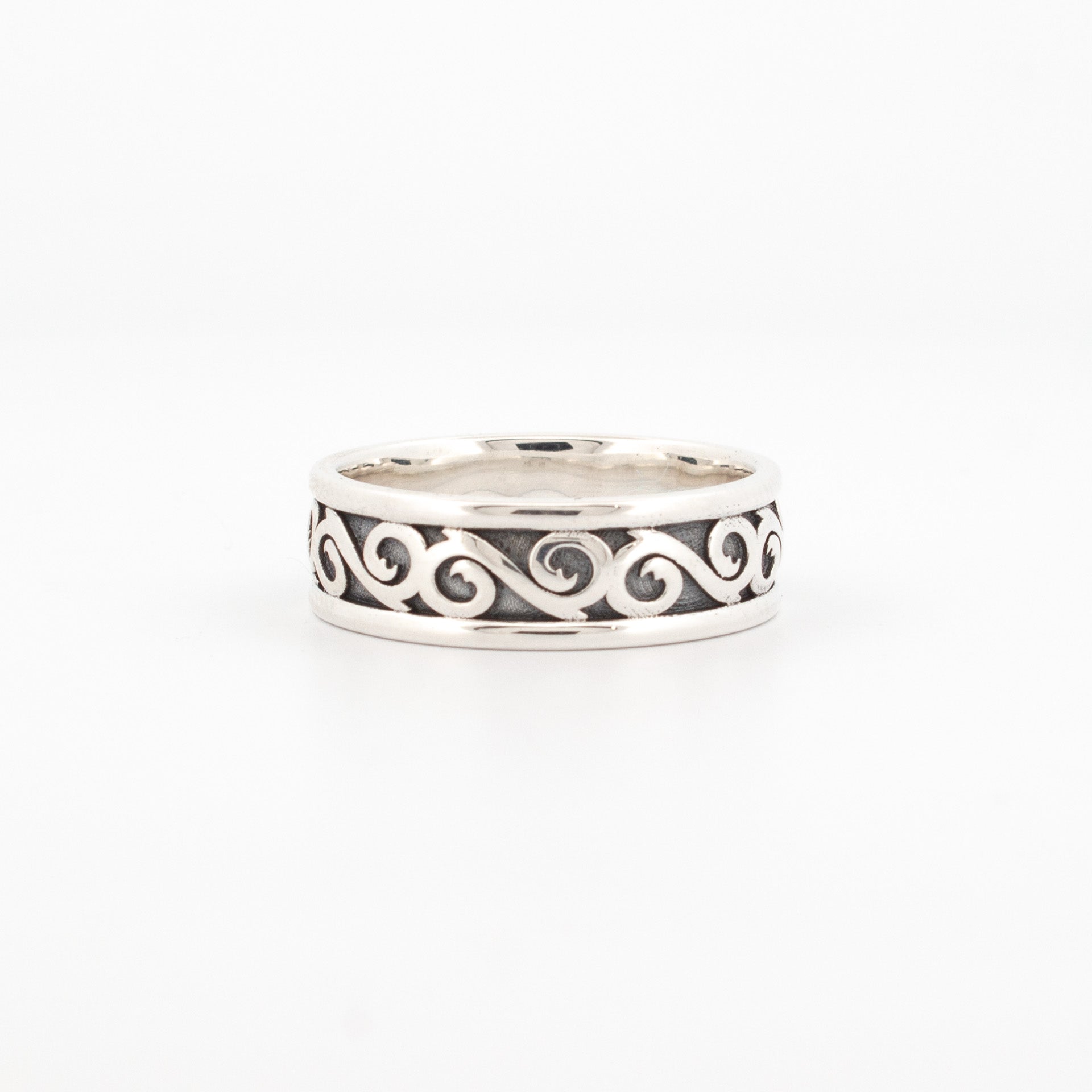 6mm sterling silver ring with oxidised recessed background and raised continuous scroll pattern, bordered by polished edges.