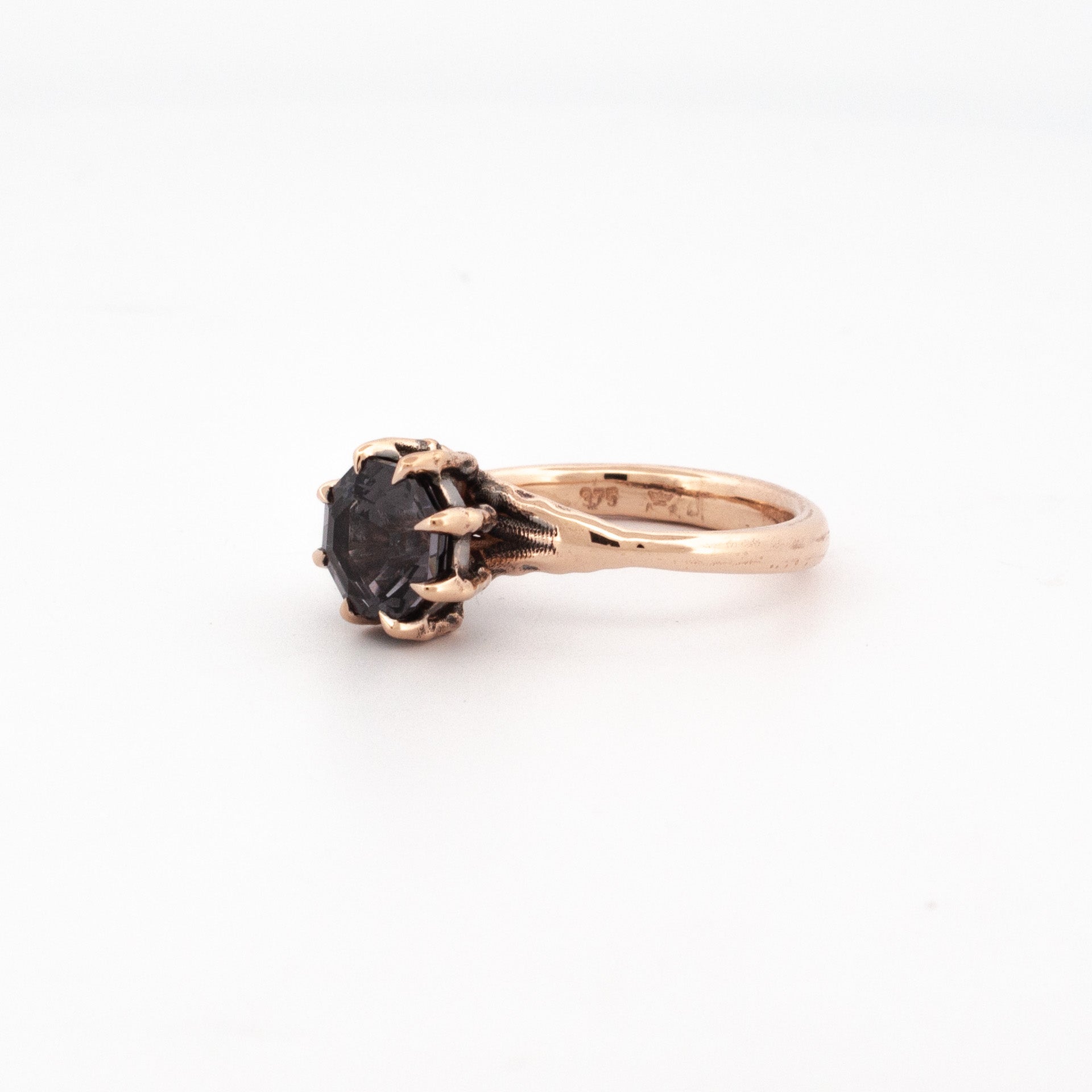 9ct rose gold ring with octagonal purple-grey spinel in claw talon setting.