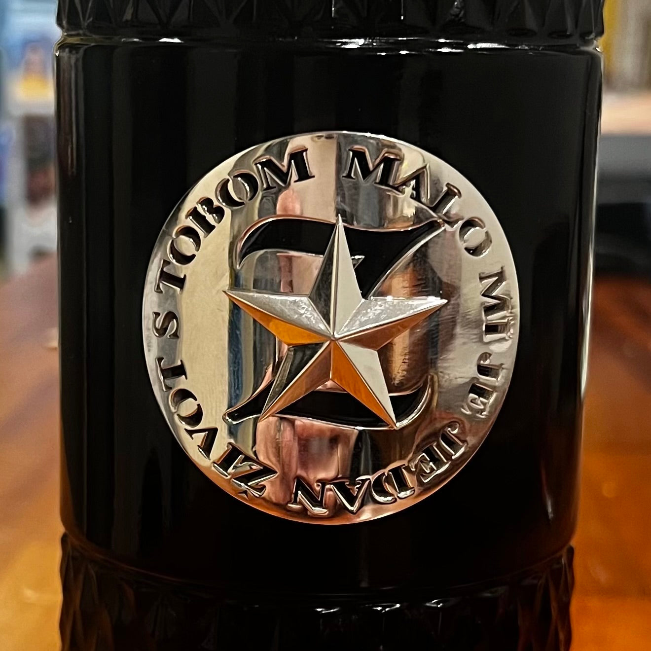 Custom memorial urn crafted in the form of a textured wine bottle, made in sterling silver with engraved Croatian lyrics 'Malo mi je jedan život s tobom' and a central star emblem; designed to hold ashes and honour a beloved husband, father, grandfather, and friend with a love of red wine, family, and music.