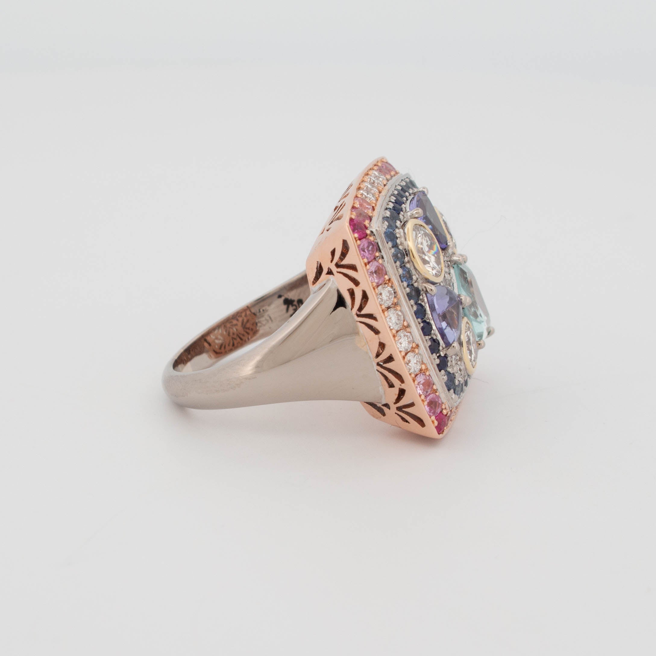 Handmade 18ct rose, white, and yellow gold ring featuring central aquamarine in geometric cut, tanzanite in triangular cuts, round brilliant cut diamonds in yellow gold bezels, and pavé-set colour fade sapphires transitioning from pink to blue.