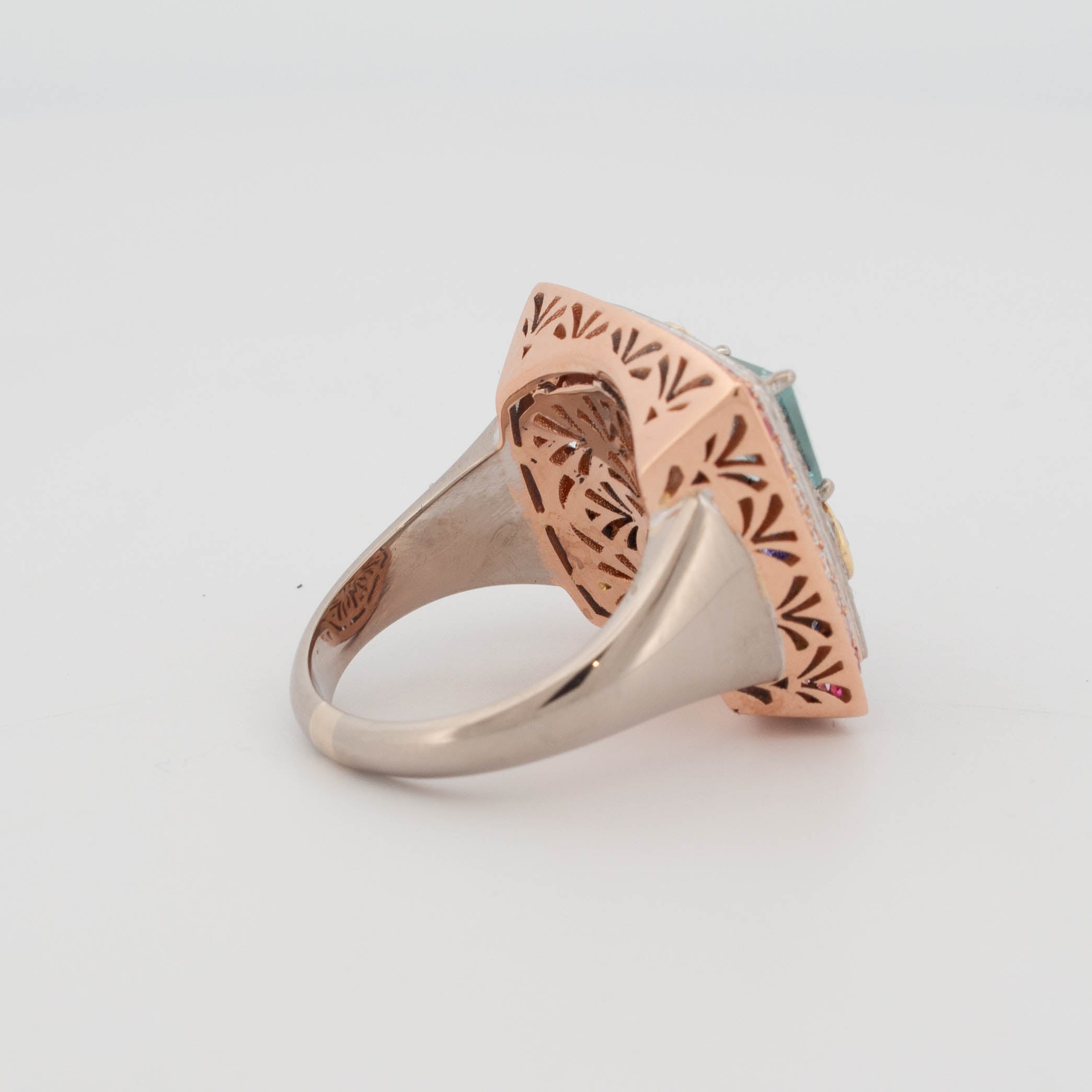 Handmade 18ct rose, white, and yellow gold ring featuring central aquamarine in geometric cut, tanzanite in triangular cuts, round brilliant cut diamonds in yellow gold bezels, and pavé-set colour fade sapphires transitioning from pink to blue.