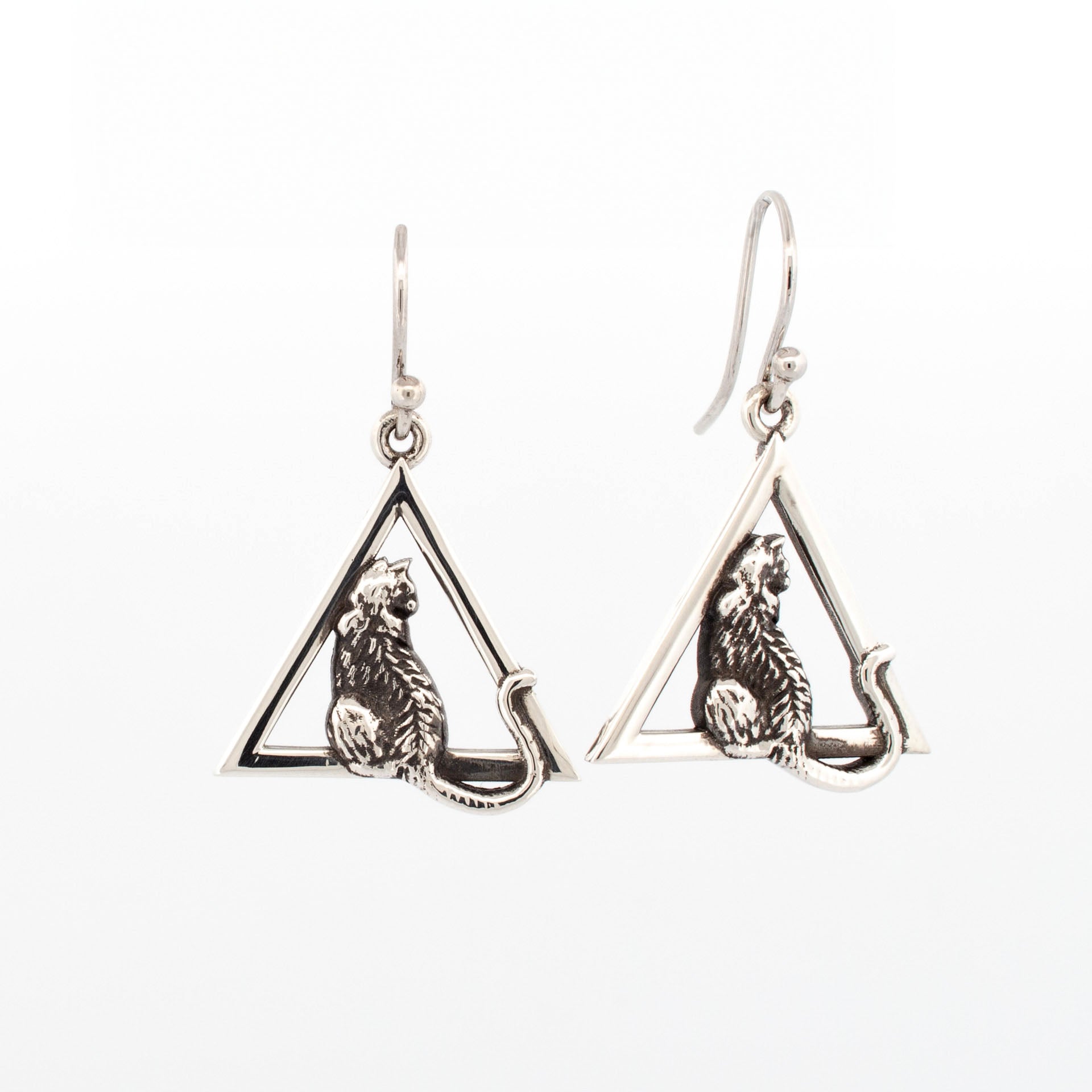 Oxidised sterling silver triangle drop earrings with detailed seated cat motif, depicting a cat looking out a window.