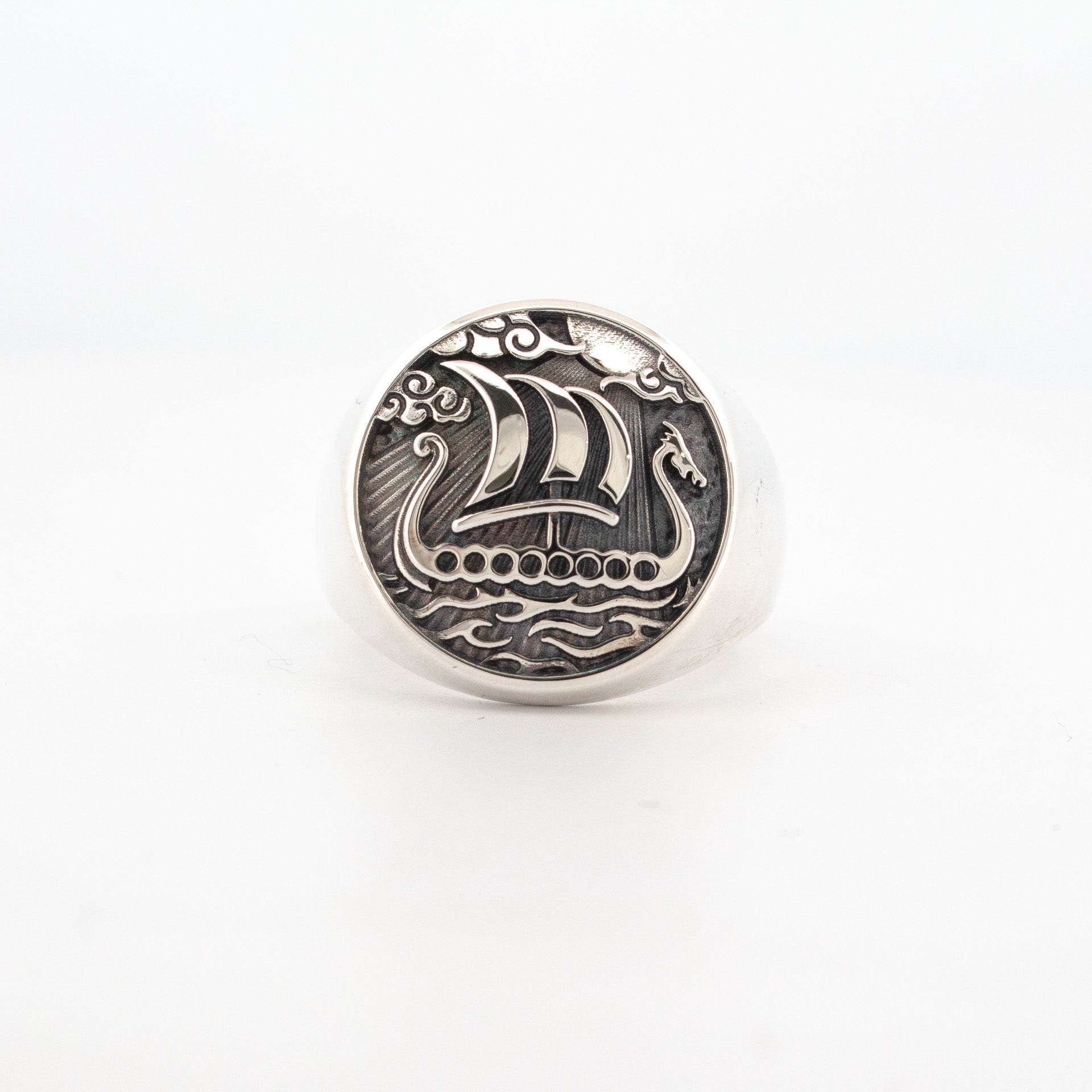 Sterling silver signet ring featuring engraved Viking longship with sail, waves, and oxidised background.