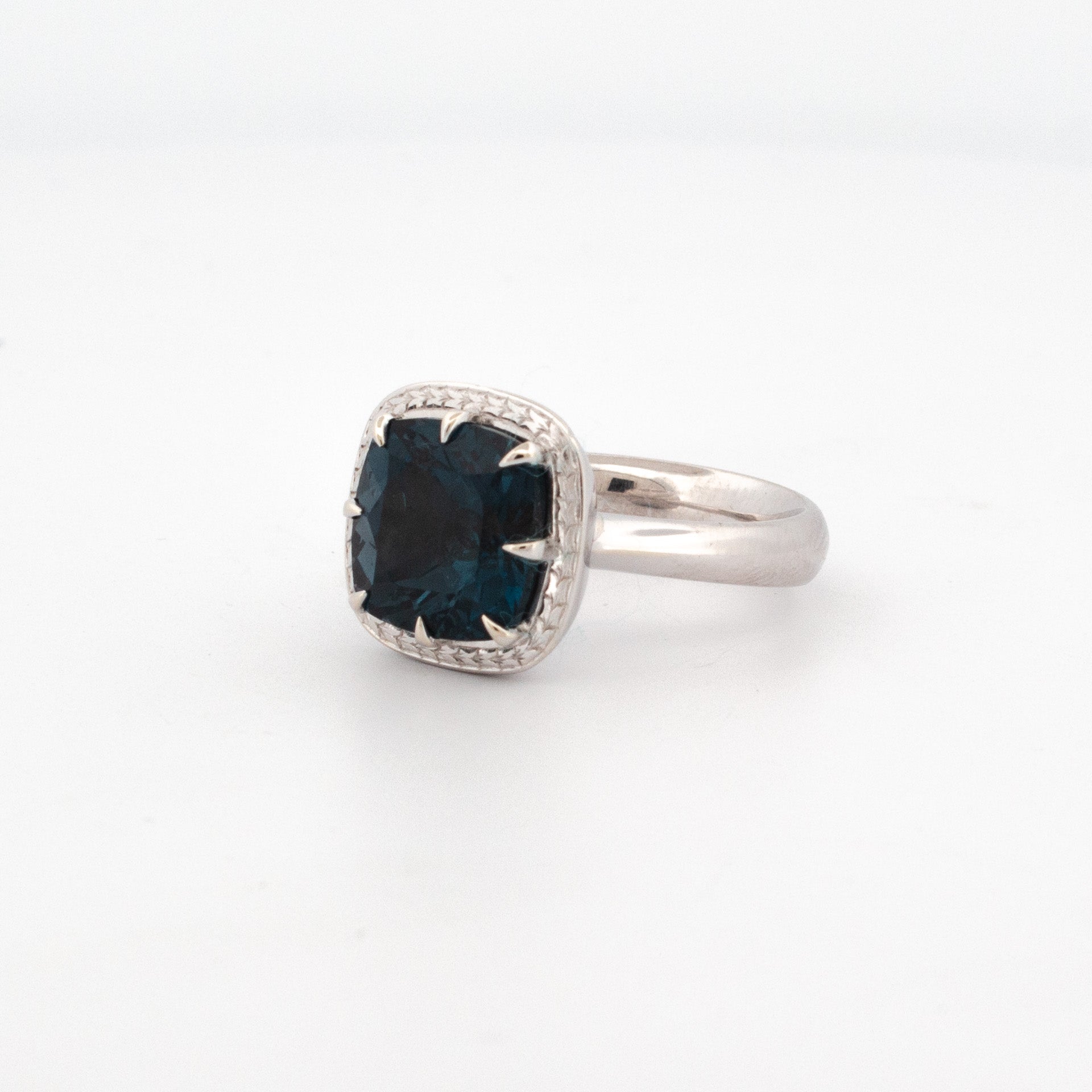 9ct white gold ring with 11mm cushion cut London Blue Topaz and hand-engraved halo detailing.