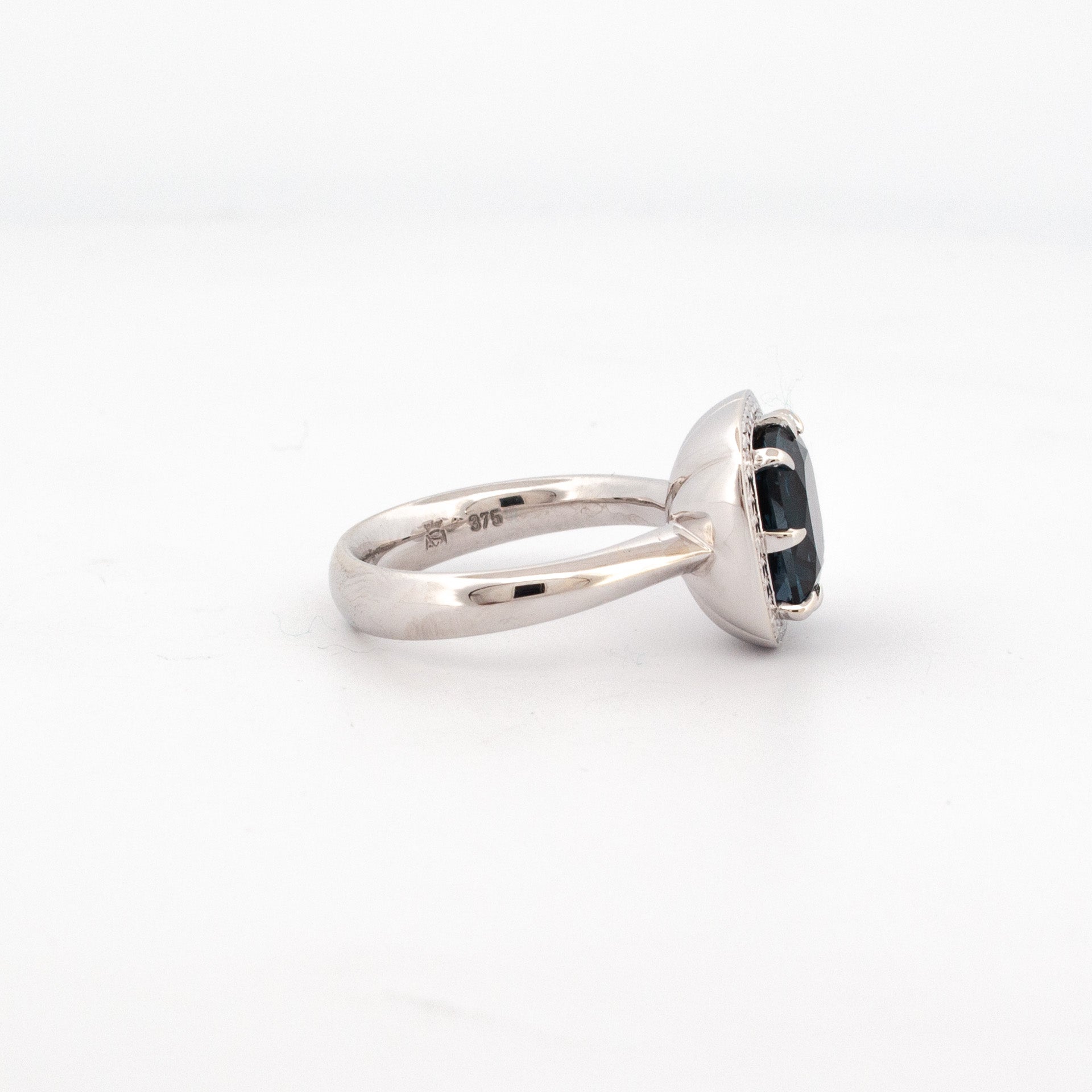 9ct white gold ring with 11mm cushion cut London Blue Topaz and hand-engraved halo detailing.