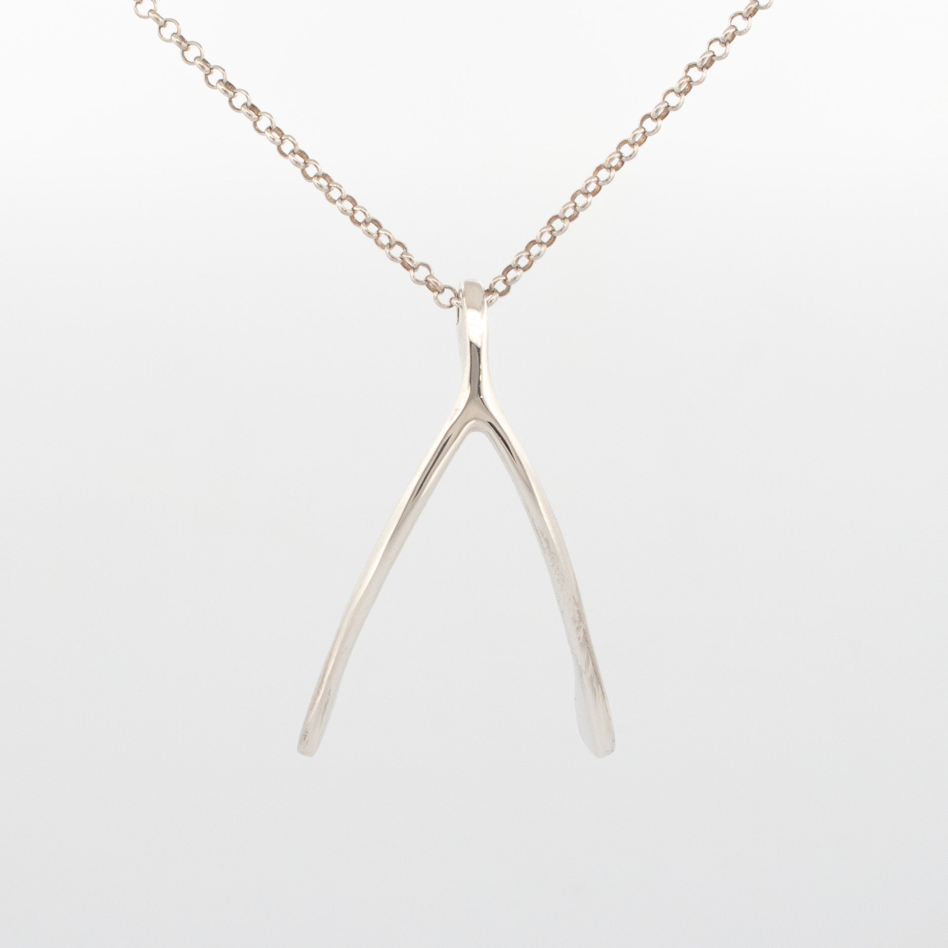 Sterling silver wishbone pendant on fine chain with polished organic finish.