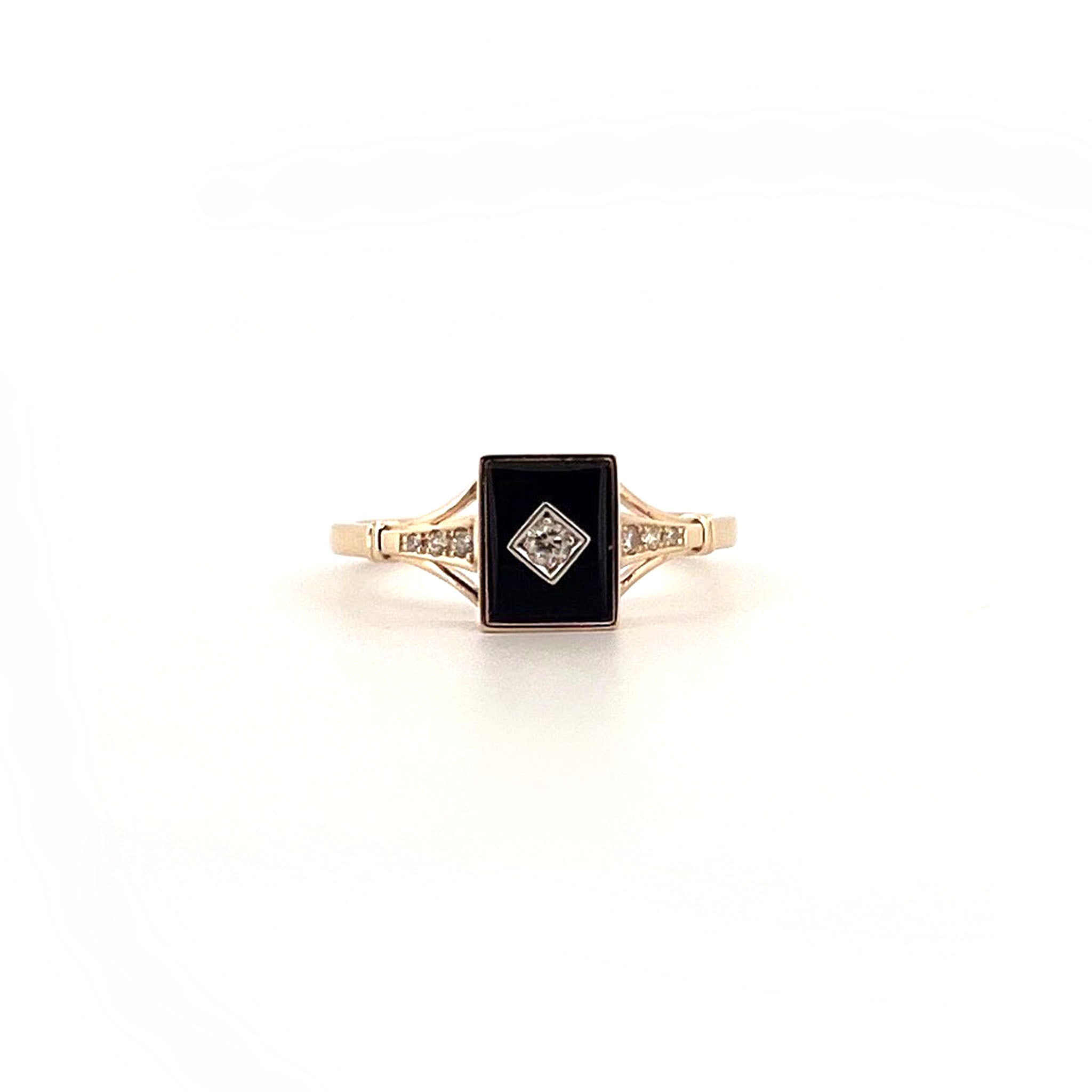 Yellow gold ring with rectangular black onyx centre, bezel-set round diamond in square setting, and diamond-accented shoulders.