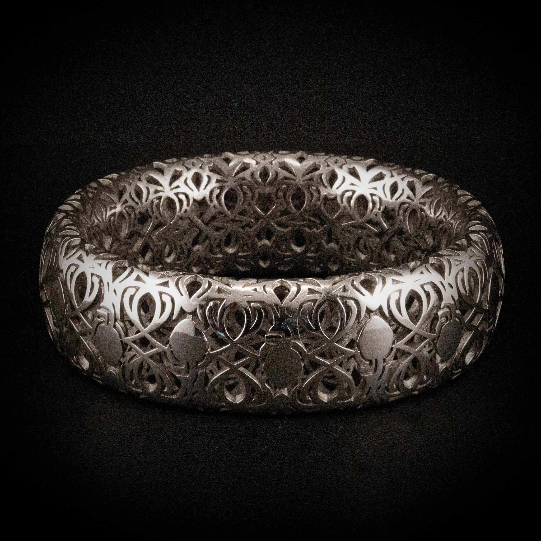 Sterling silver wide bangle bracelet titled Complicated Hearts, featuring intricate openwork design of interlocking heart motifs in continuous repeating pattern.