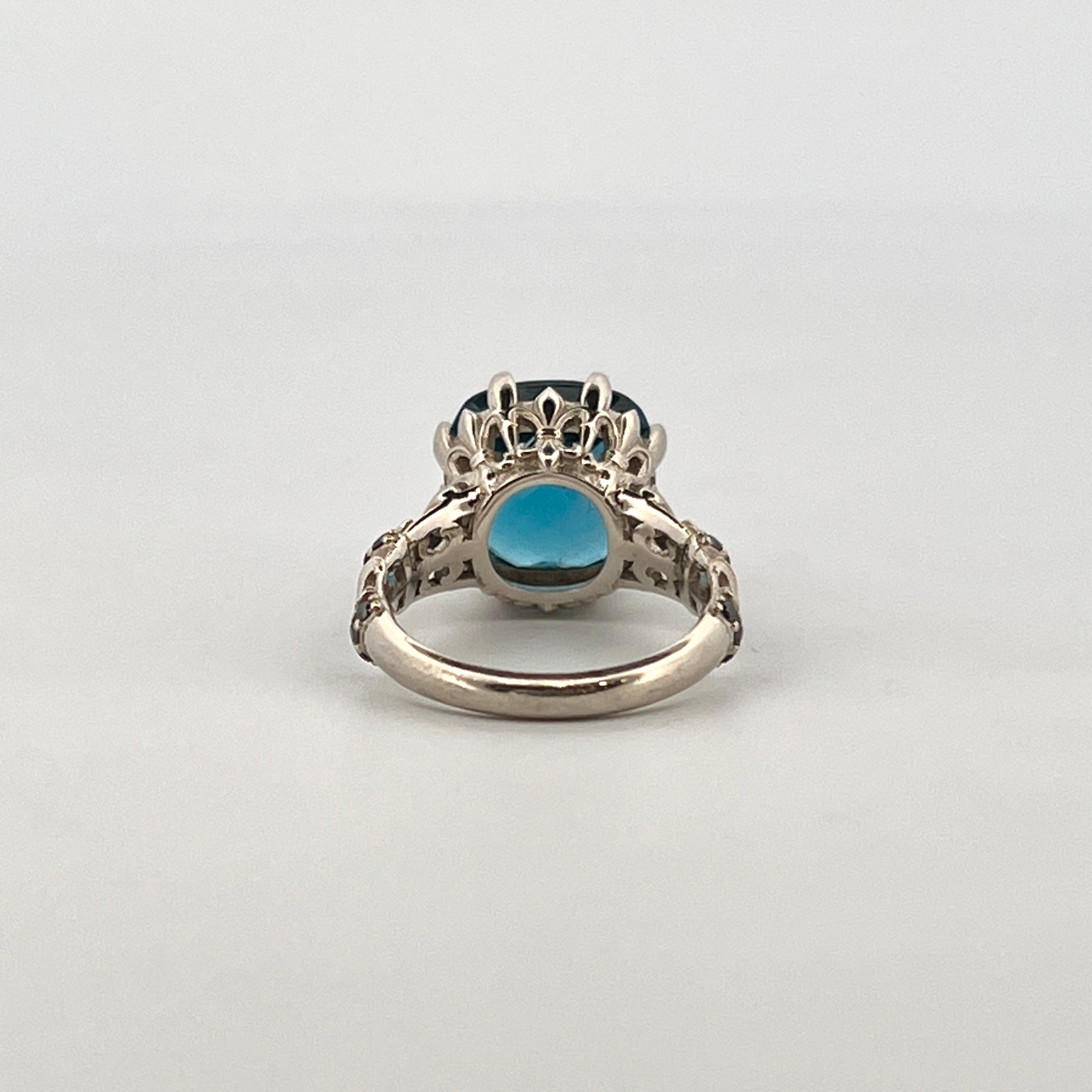 9ct white gold ring with 12mm cushion cut London Blue Topaz checkerboard surface and black diamond accents.