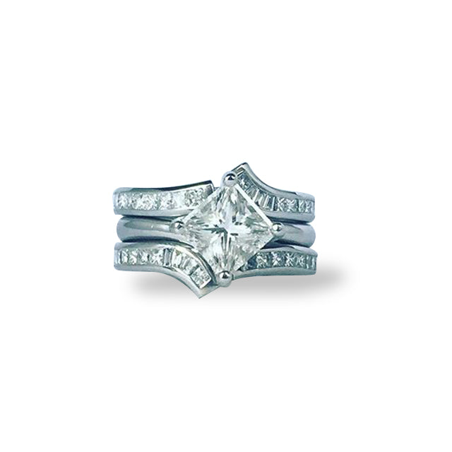 18ct white gold ring with princess-cut diamond centre and pavé-set baguette and brilliant cut diamonds.