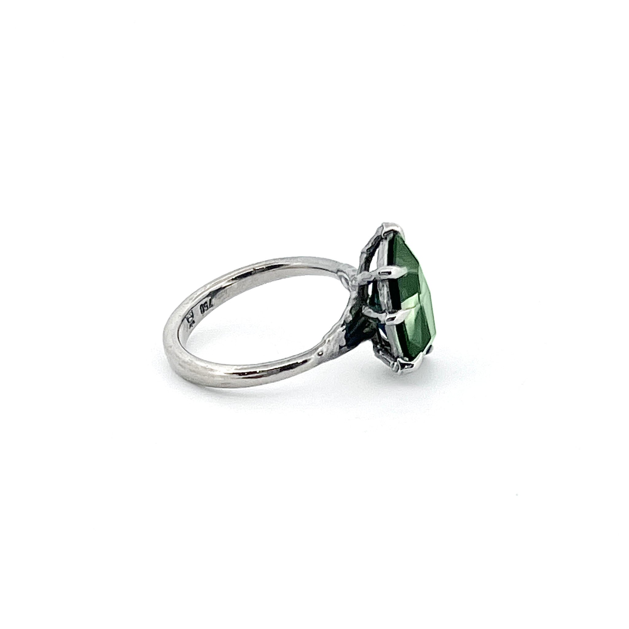 18ct White gold ring with shield-cut green tourmaline in six-claw setting, featuring geometric faceted design and polished band.