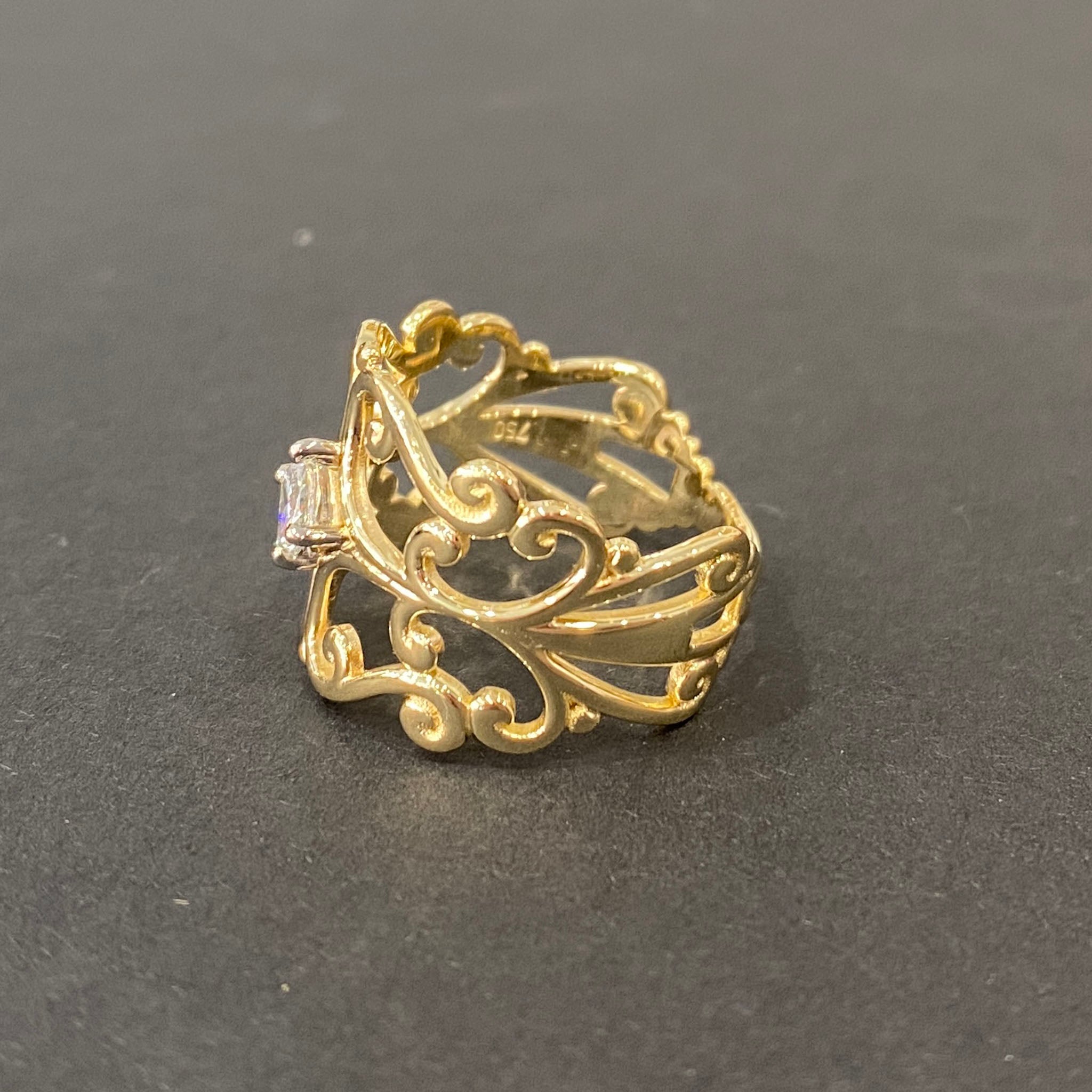 Yellow gold scrollwork ring featuring a central princess-cut diamond in claw setting, crafted by reusing gold and diamond from an old ring.