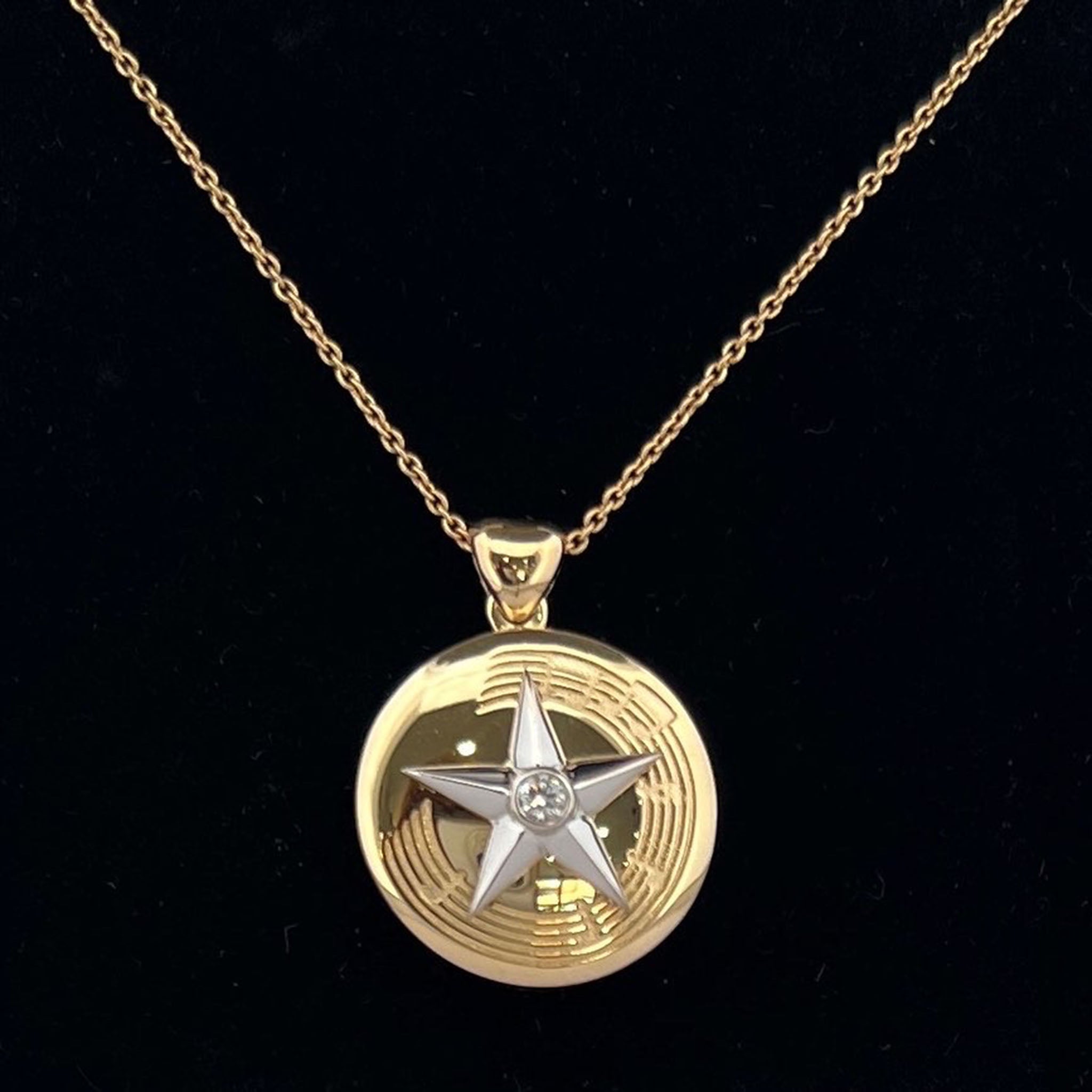18ct yellow and white gold memorial pendant with hidden compartment for ashes, front featuring raised star with central diamond, reverse engraved with “Z” and song words with musical notation.
