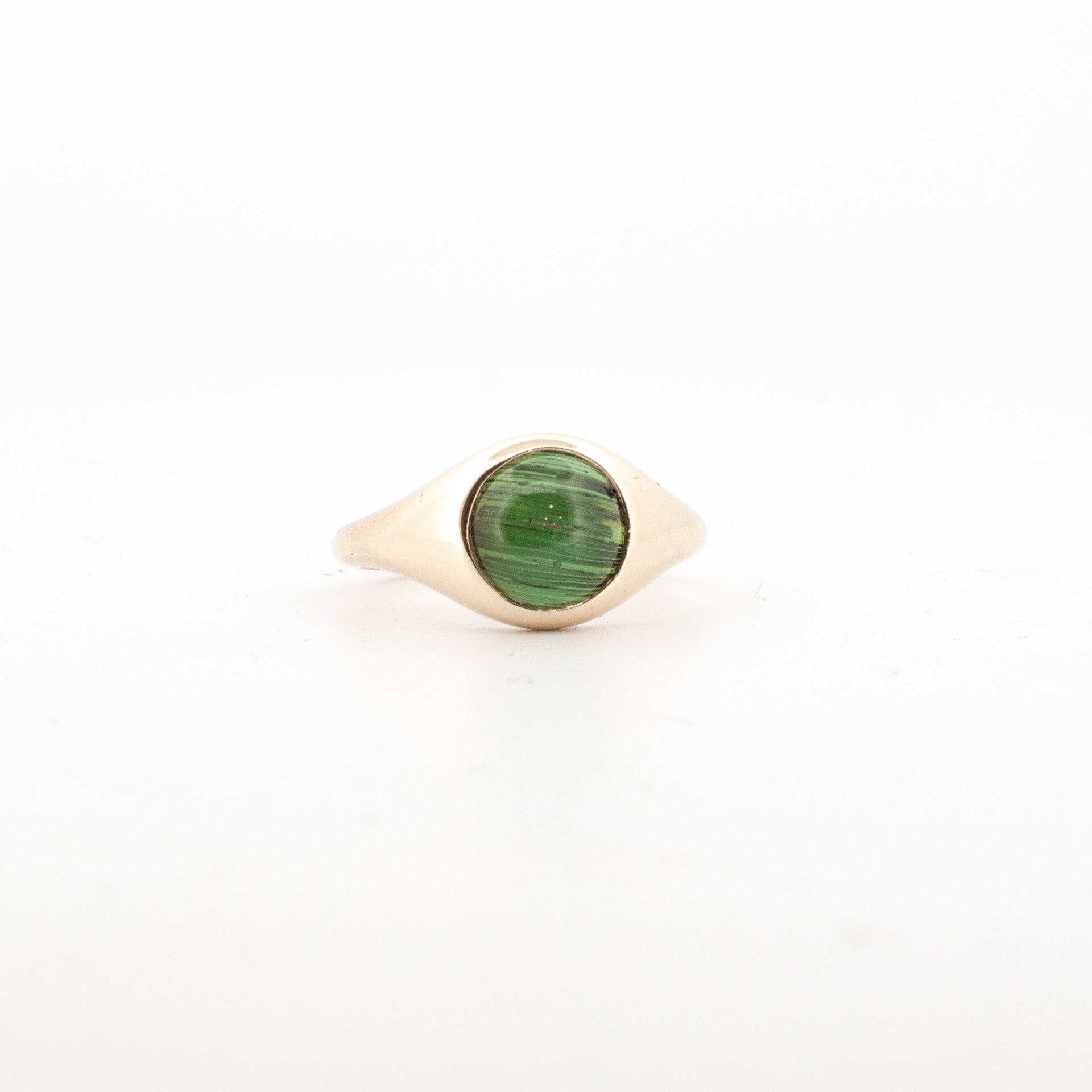 9ct yellow gold ring with bezel-set green cat’s eye tourmaline cabochon.

