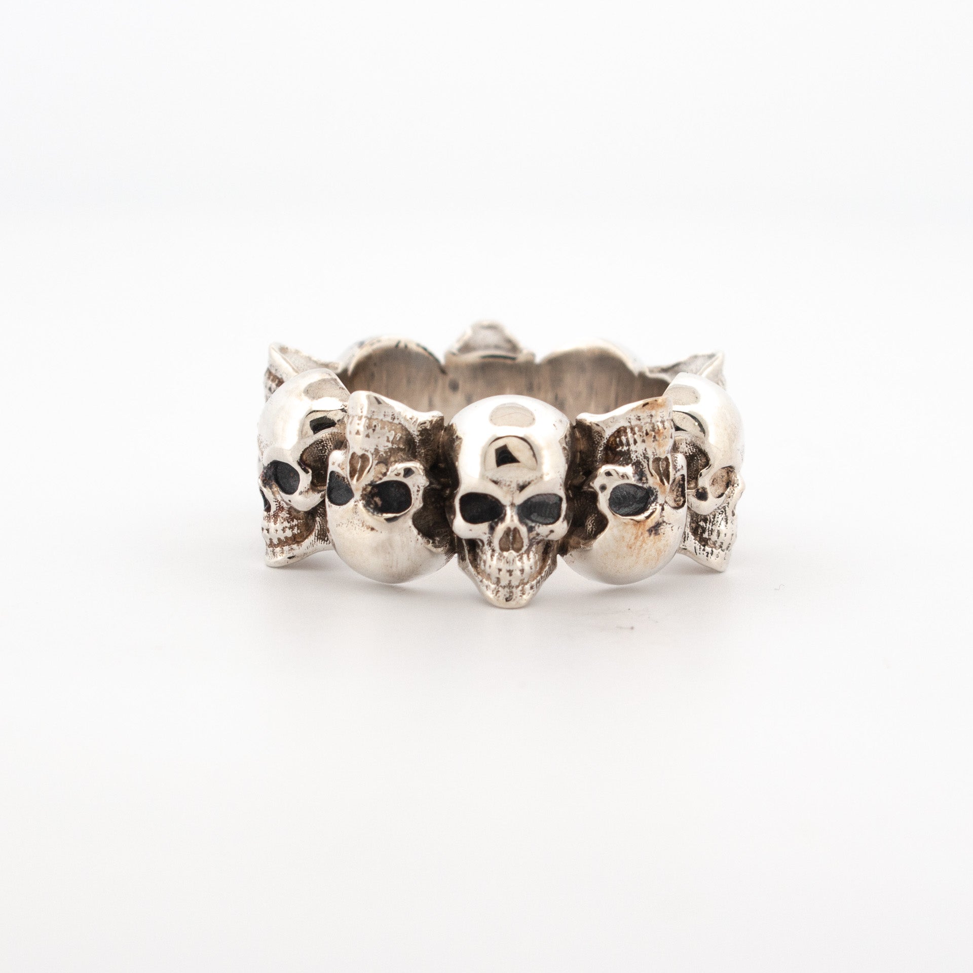 Sterling silver ring with continuous row of oxidised skulls in high-relief design.