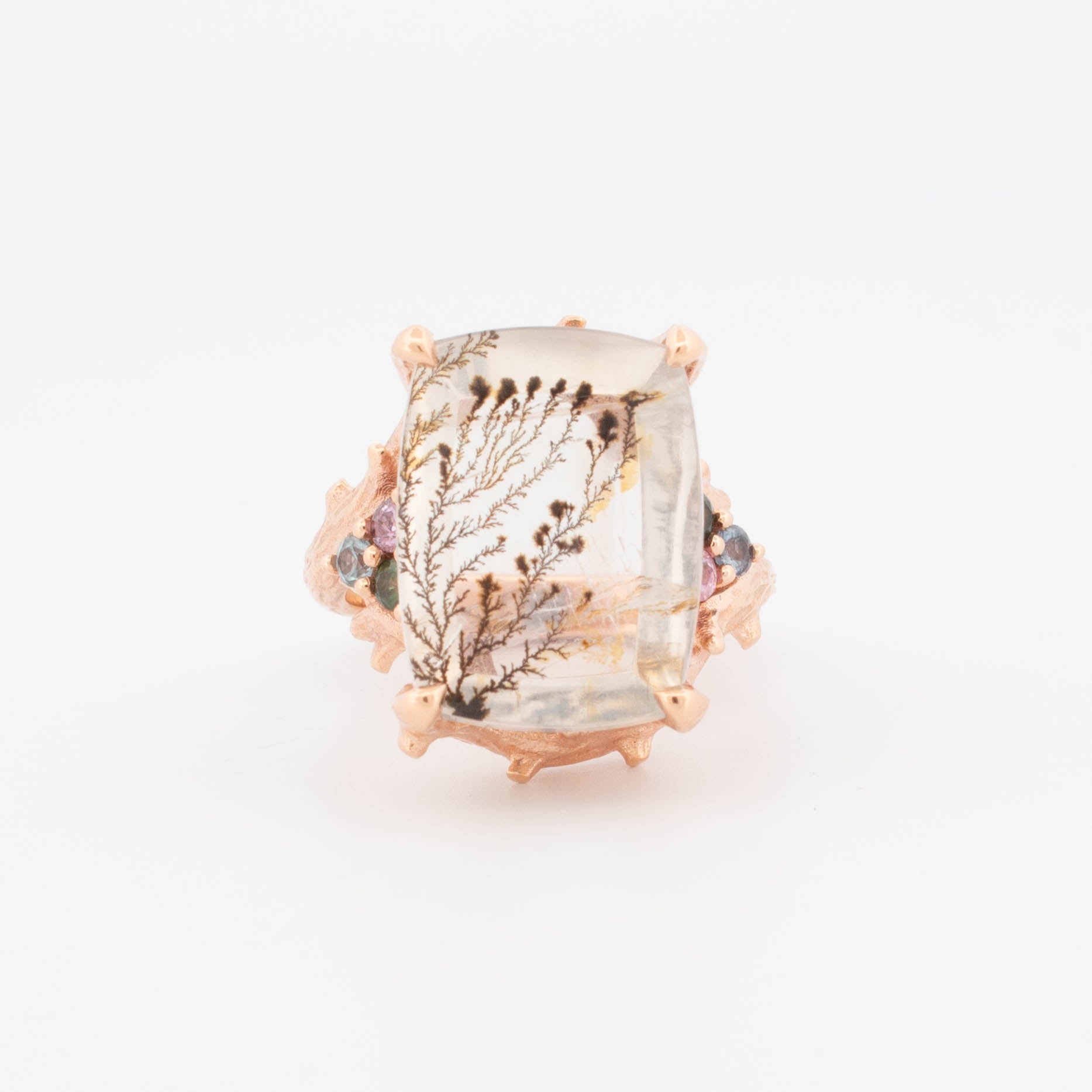9ct rose gold ring featuring a large rectangular dendritic quartz with natural fern-like inclusions, accented by multi-coloured faceted shoulder stones in a textured organic setting.