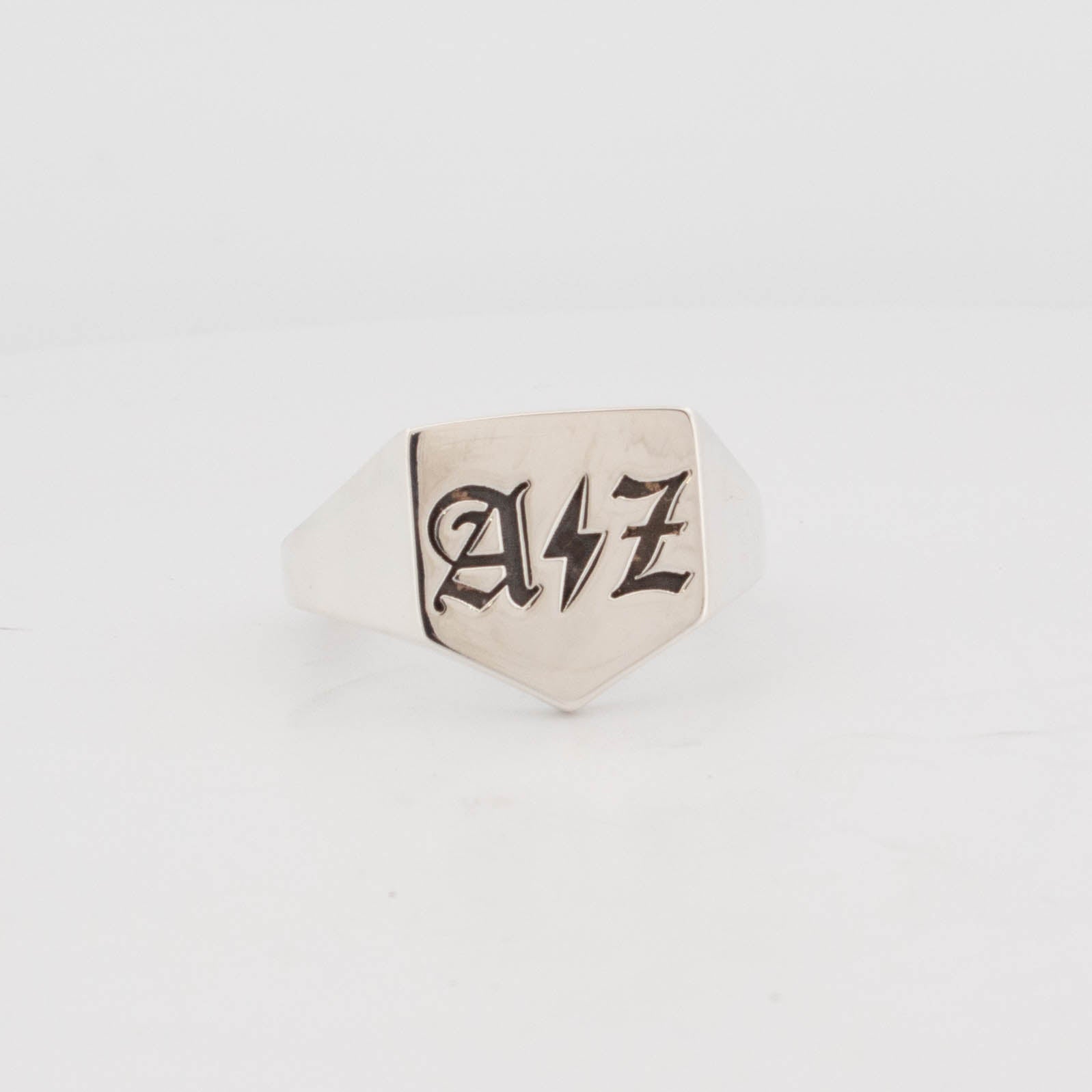 Sterling silver signet ring with engraved gothic-style "A/Z" initials and lightning bolt detail on a polished shield-shaped face; sold as-is, showcasing example of custom initial engraving available on request.