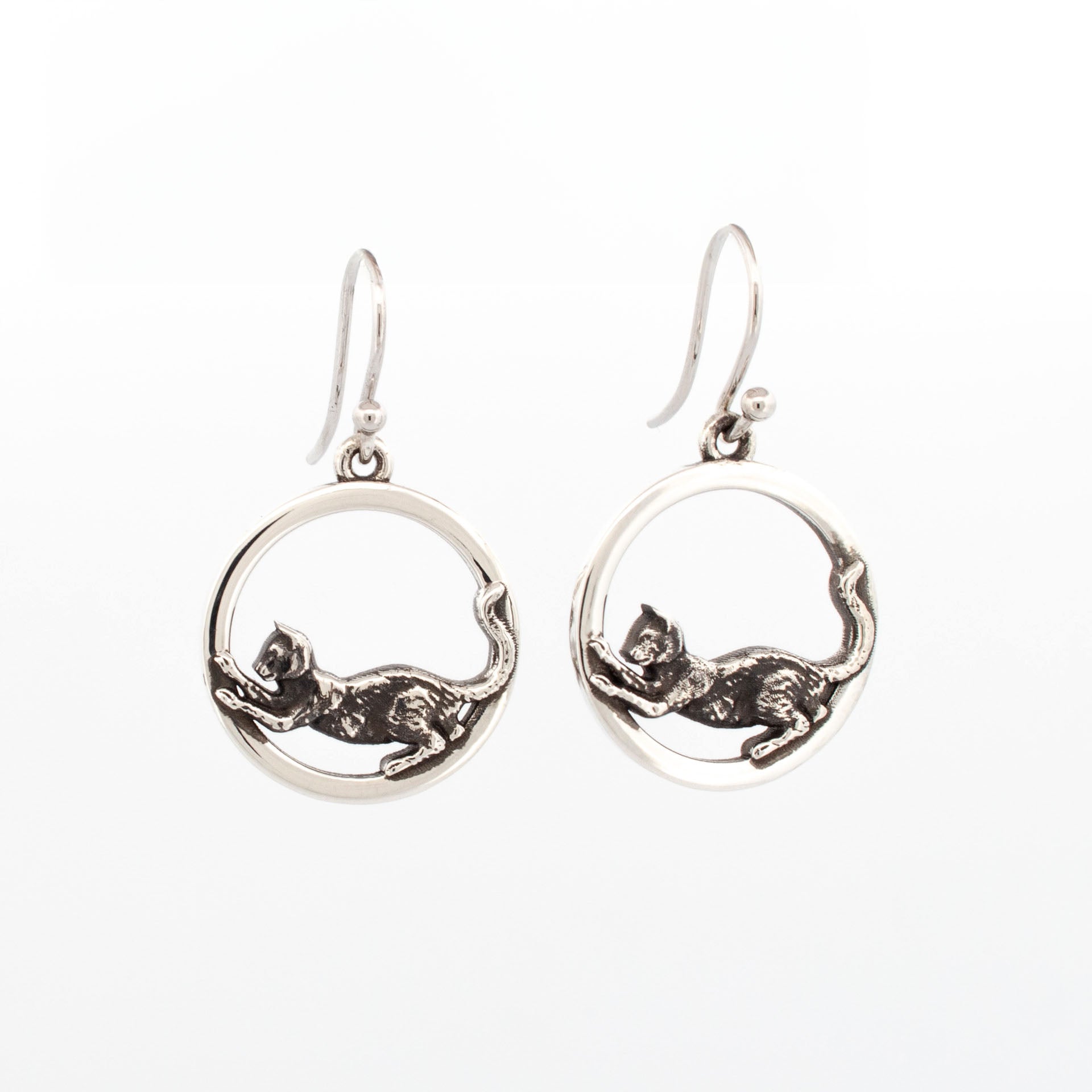 Sterling silver round drop earrings with oxidised stretching cat design inside polished circular frames.