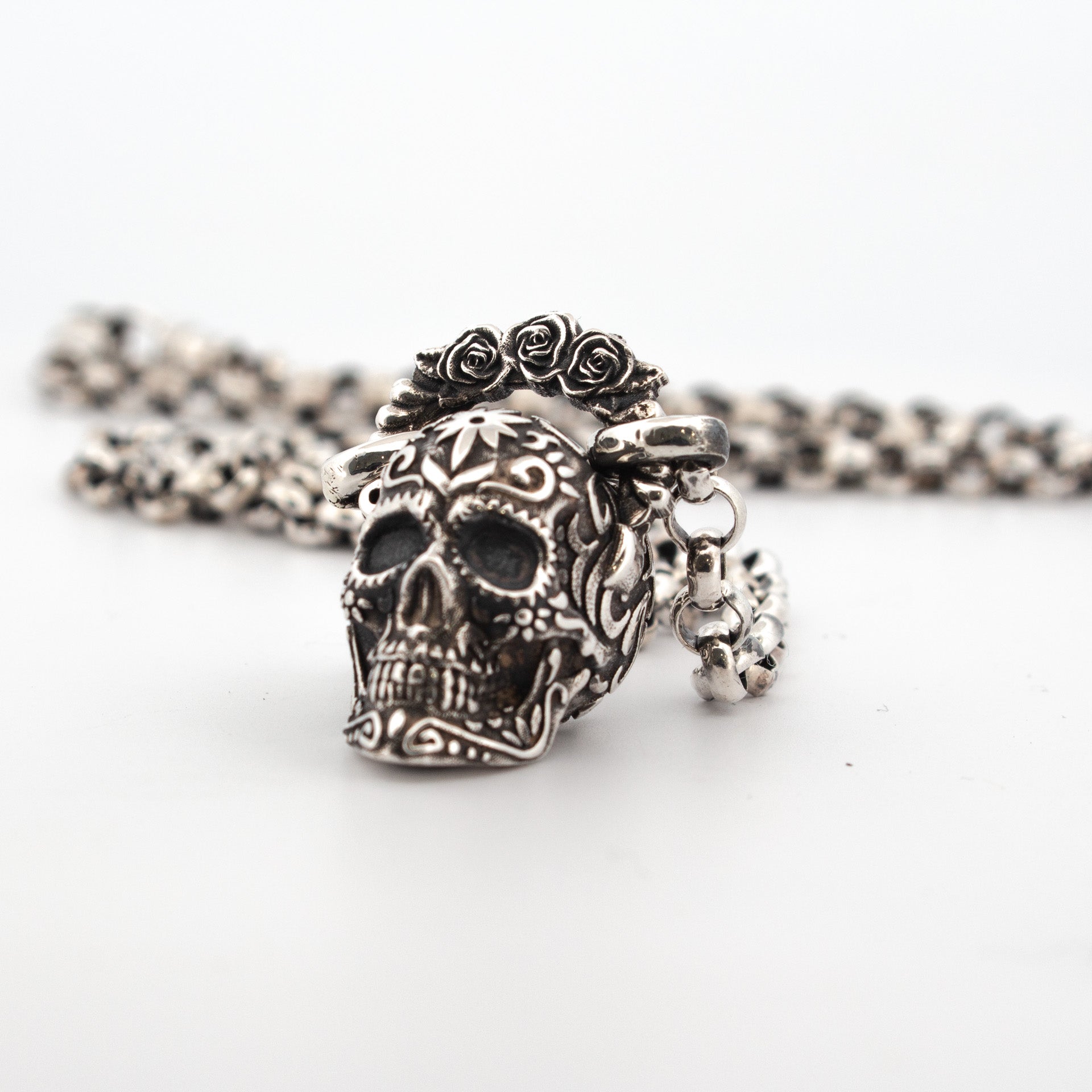 Sterling silver sugar skull locket with floral crown, oxidised detailing, and hidden compartment.