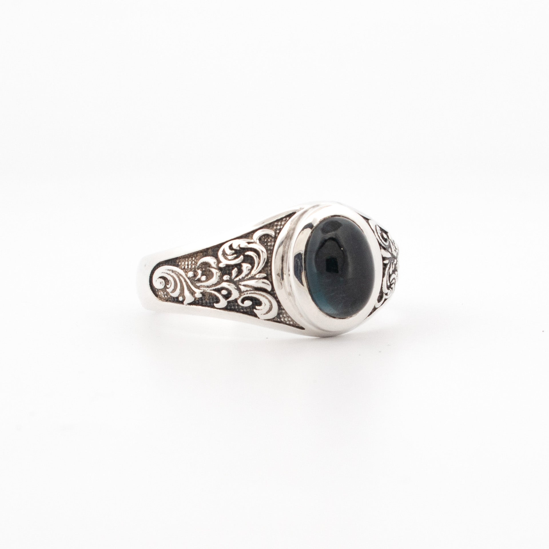 A sterling silver ring featuring an oval London Blue Topaz with engraved shoulder details.