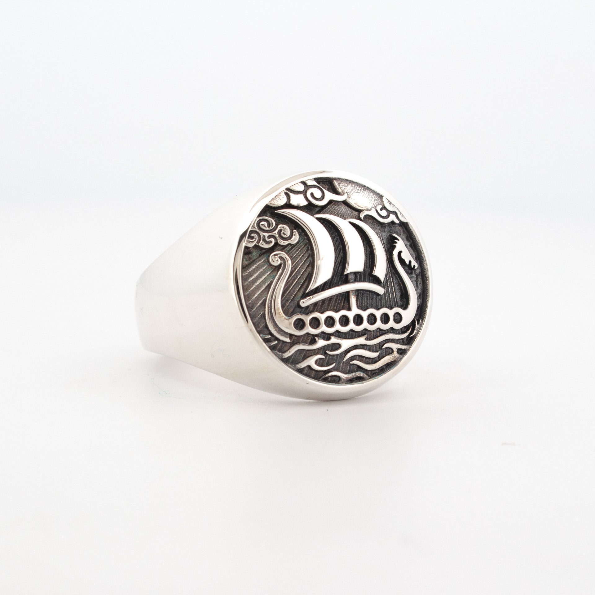 Sterling silver signet ring featuring engraved Viking longship with sail, waves, and oxidised background.