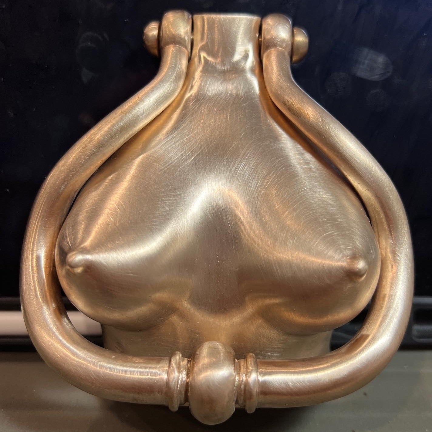Bronze patinated door knocker sculpted in the form of a torso with stylised curves, artistic figurative hardware