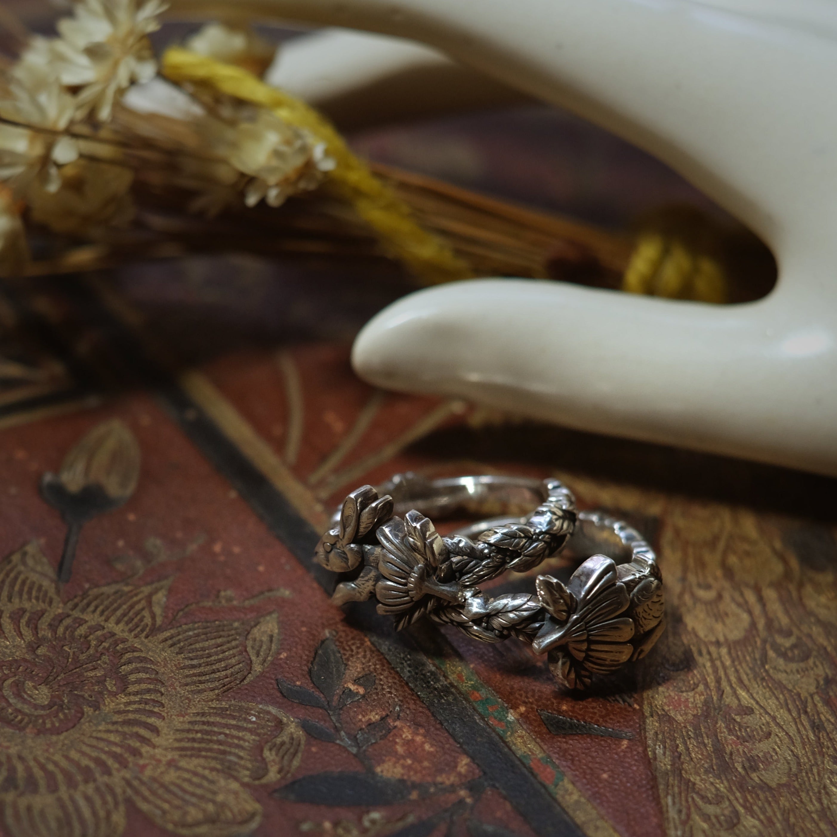 Sterling silver rings with sculpted bunny, owl and floral motifs, detailed woodland design with braided band texture
