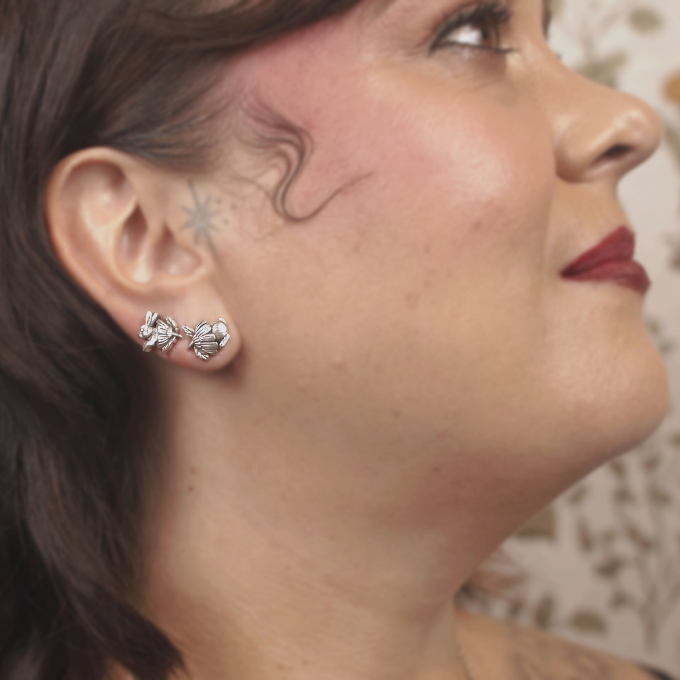 Sterling silver bunny stud earrings showing front and back half of bunny nestled in daisy flower caps, handmade whimsical design